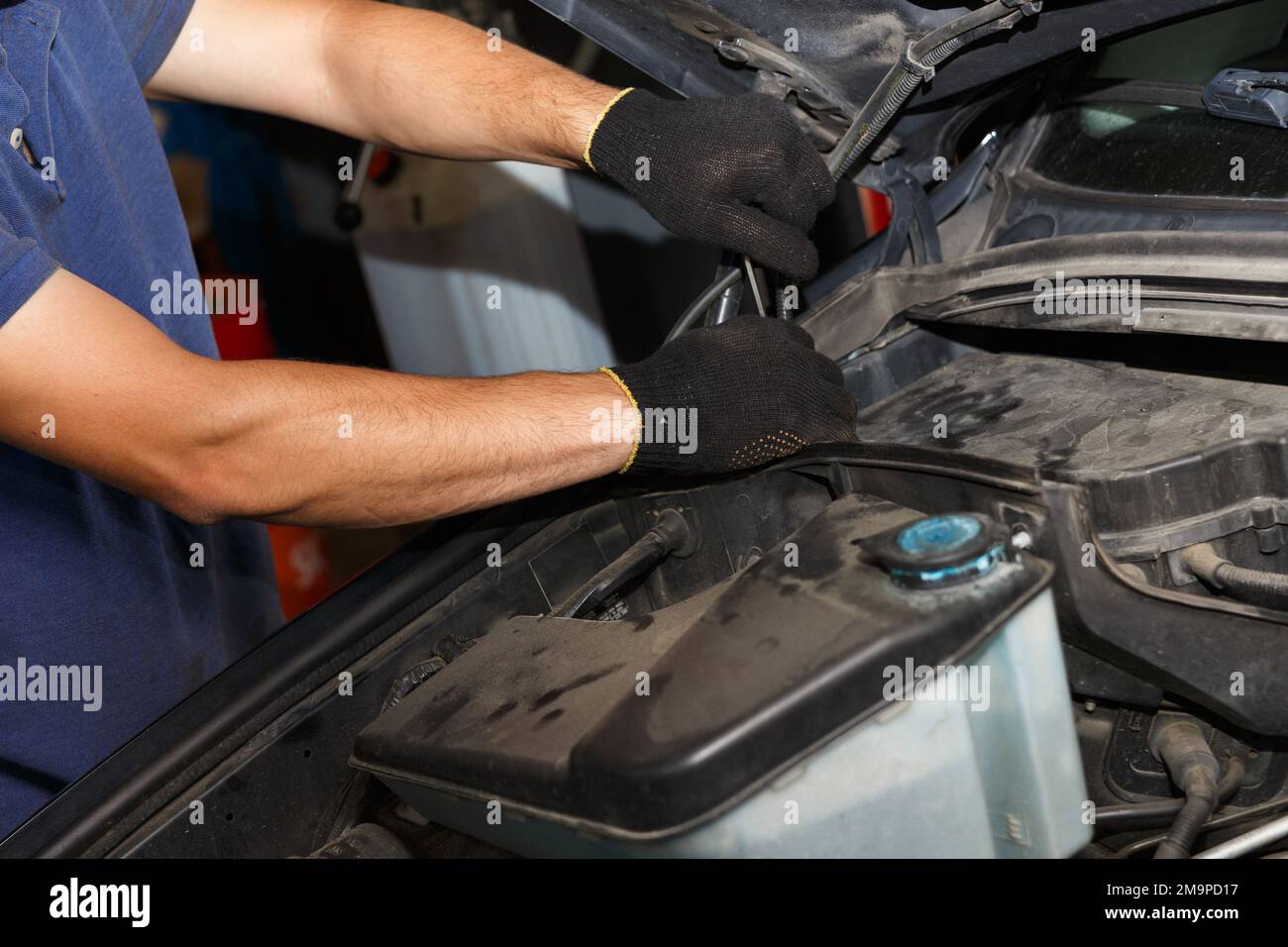 Car service, repair, maintenance and people concept - auto mechanic looking for a malfunction in the car engine. Mechanic hands checking up of service Stock Photo