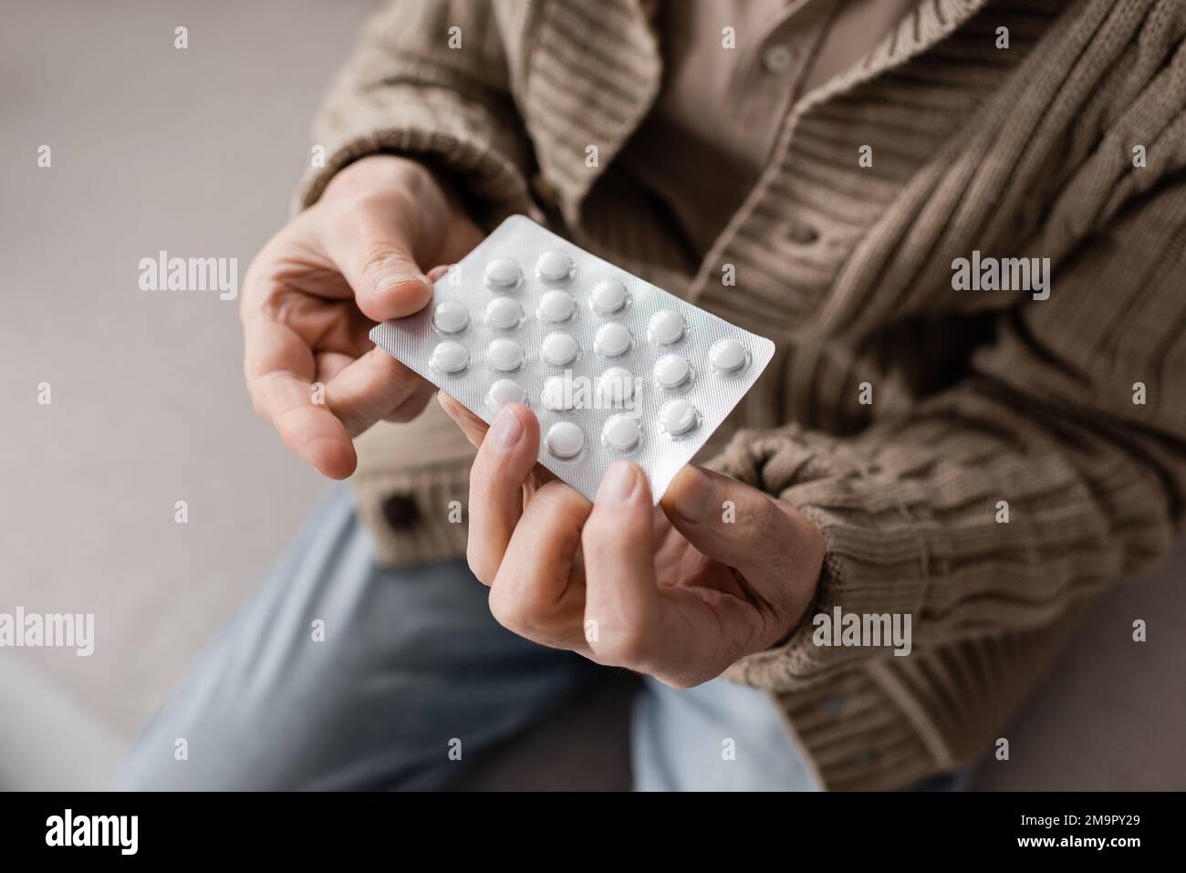 partial view of aged man with parkinsonian syndrome holding pills in trembling hands,stock image Stock Photo