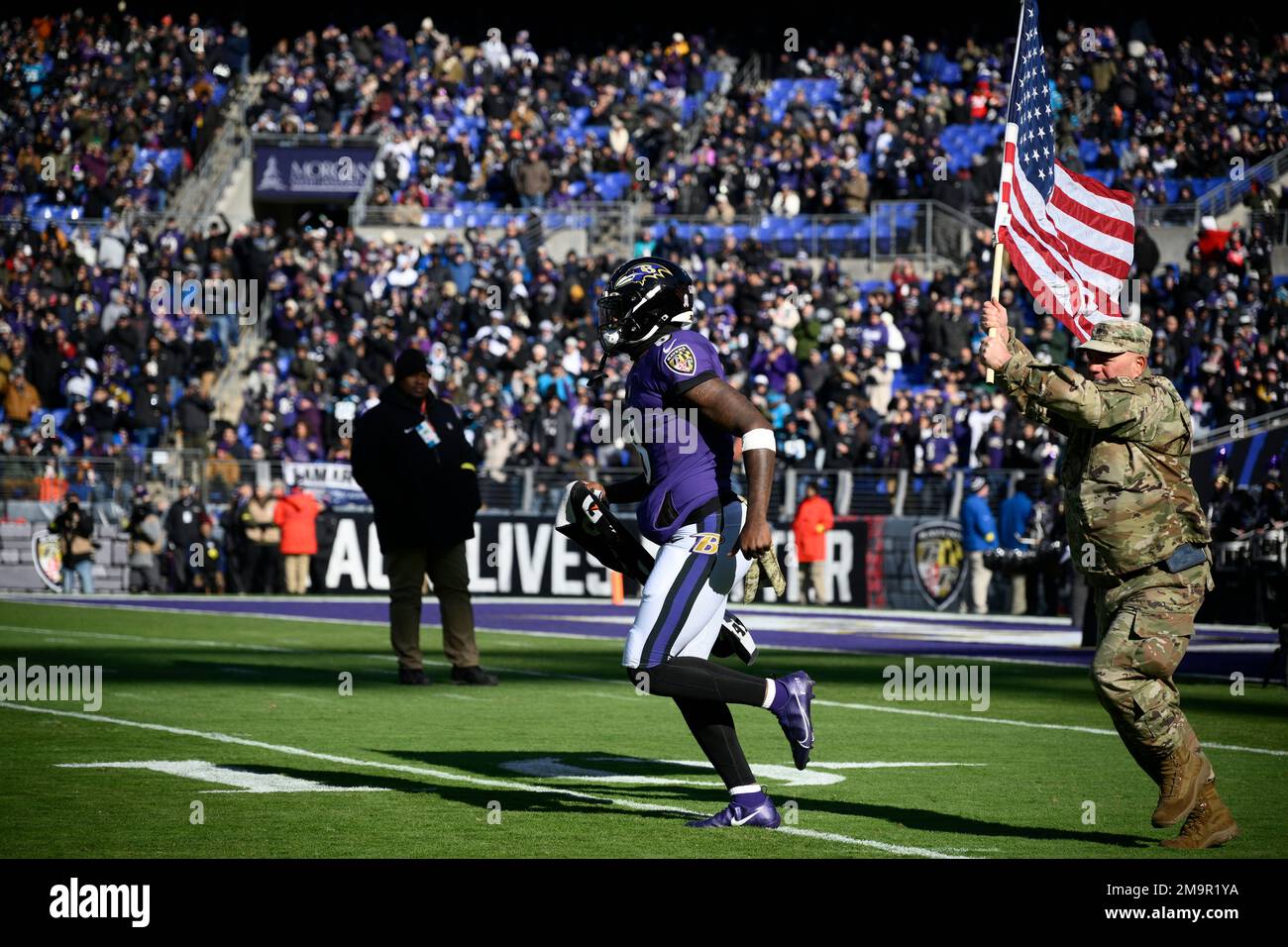 Baltimore Ravens quarterback Lamar Jackson (8) takes to the field with a  member of the military as part of Salute to Service before an NFL football  game against the Carolina Panthers, Sunday,