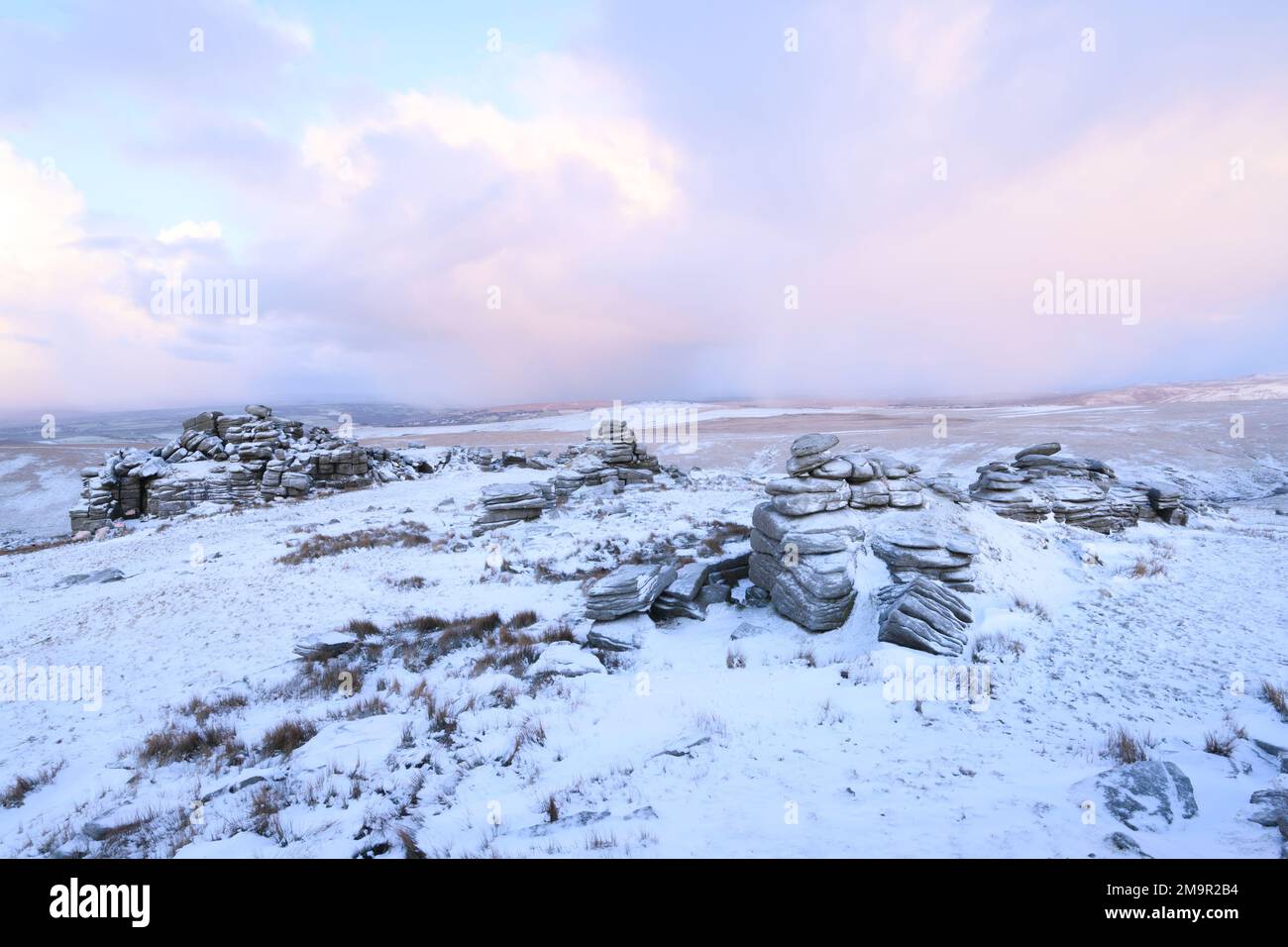 Dartmoor National Park, Devon, UK. 18th Jan, 2023. UK Weather: A wintery sunrise on Dartmoor as overnight snow covers the western edge of the moor. Pictured is Great Mis Tor near Merrivale. Credit: Celia McMahon/Alamy Live News Stock Photo