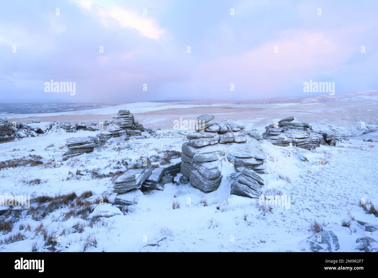 Dartmoor National Park, Devon, UK. 18th Jan, 2023. UK Weather: A wintery sunrise on Dartmoor as overnight snow covers the western edge of the moor. Pictured is Great Mis Tor near Merrivale. Credit: Celia McMahon/Alamy Live News Stock Photo