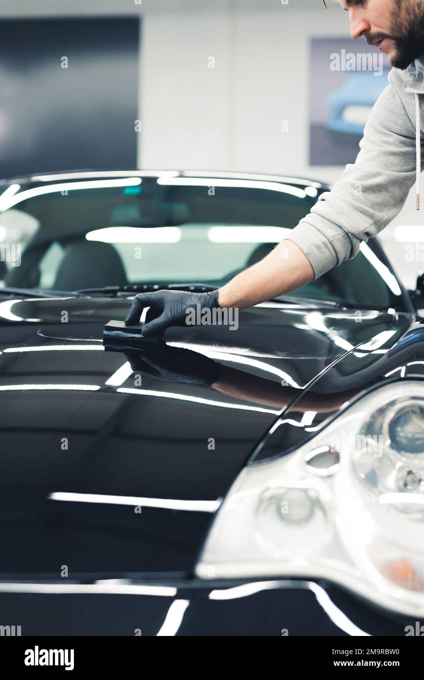 Ceramic coating concept. Man doing car detailing services and coating