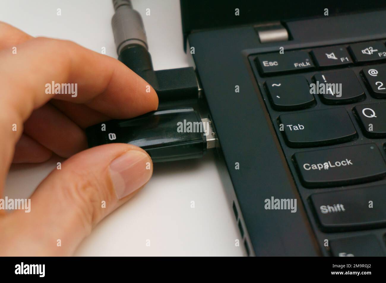 person plug in usb drive into laptop port Stock Photo