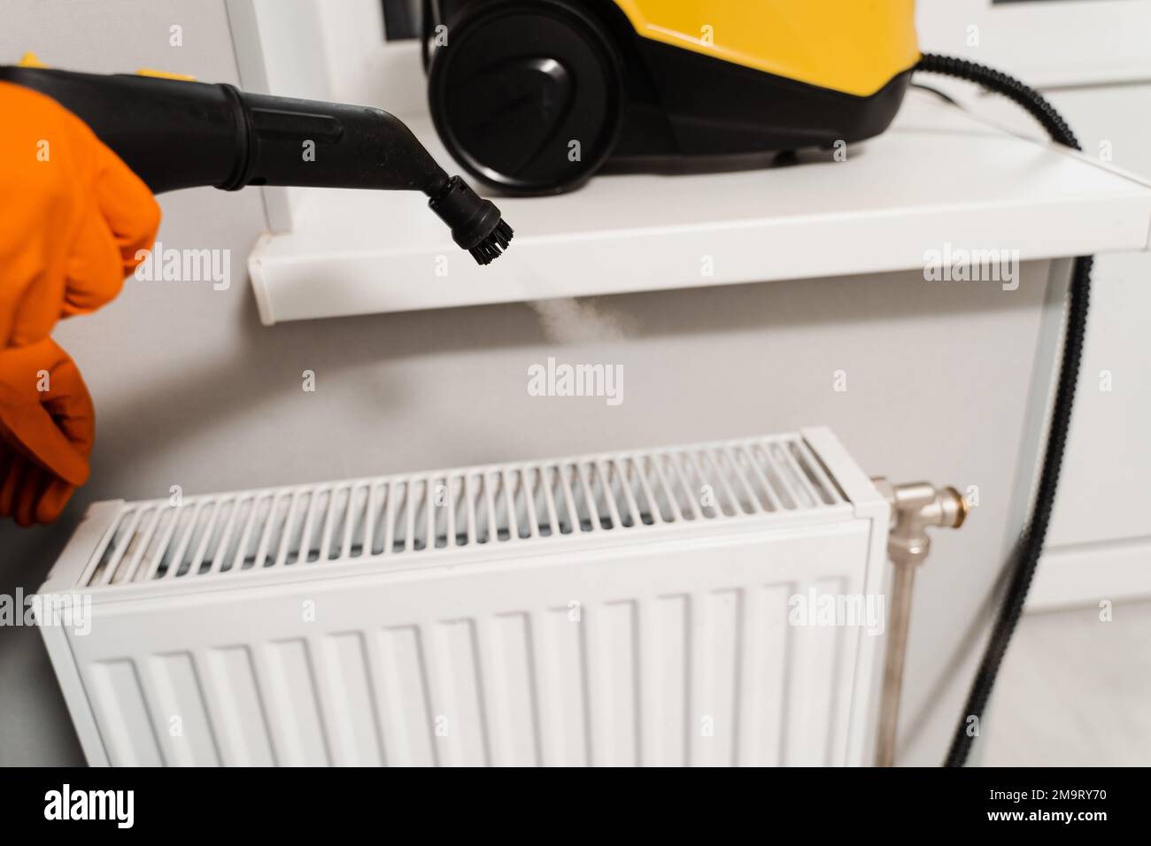 Professional cleaner is disinfecting heating radiator. Professional cleaning  service cleans dirt and dust at home. Steam cleaning of heating battery a  Stock Photo - Alamy