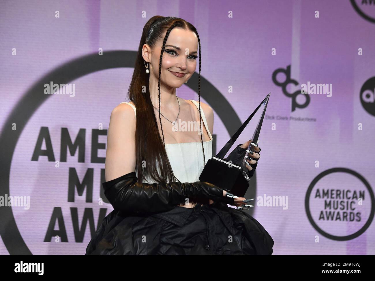 Dove Cameron poses in the press room with the award for new artist of
