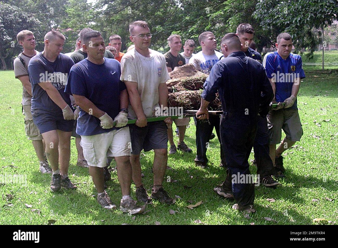 US Marine Corps (USMC) members from Vertical Marine Fighter Attack Squadron 212 (VMFA-212) based at Marine Corps Air Station (MCAS) Iwakuni, Japan, carry fallen trees away from land used by intellectually disabled children, near Paya Lebar, Singapore, during Exercise Commando Sling with the Singaporean Royal Air Force. Base: Paya Lebar Country: Singapore (SGP) Stock Photo