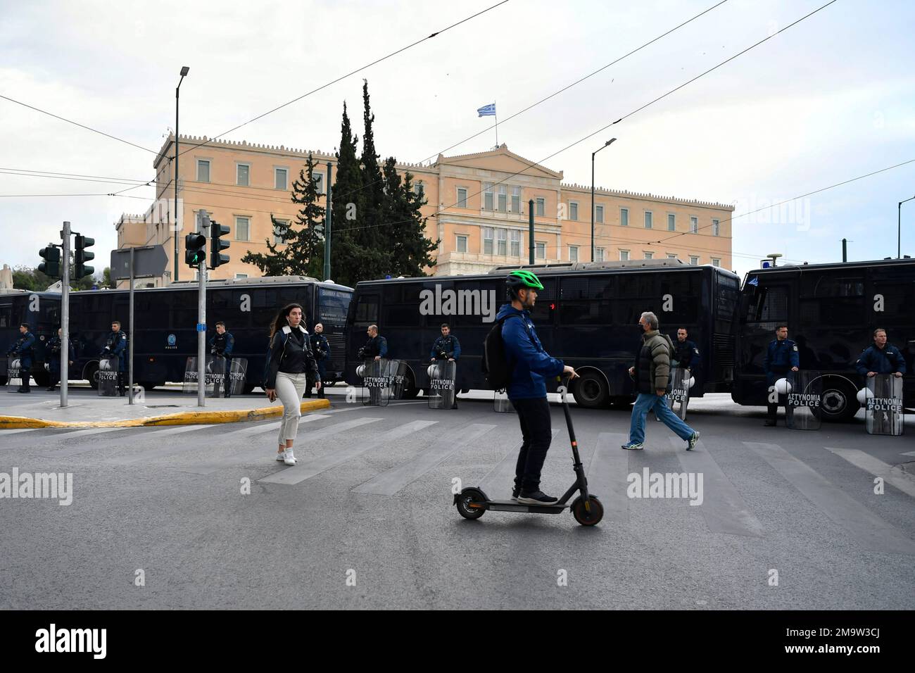 A man passes with a scooter in front of police buses blocked the roads ...