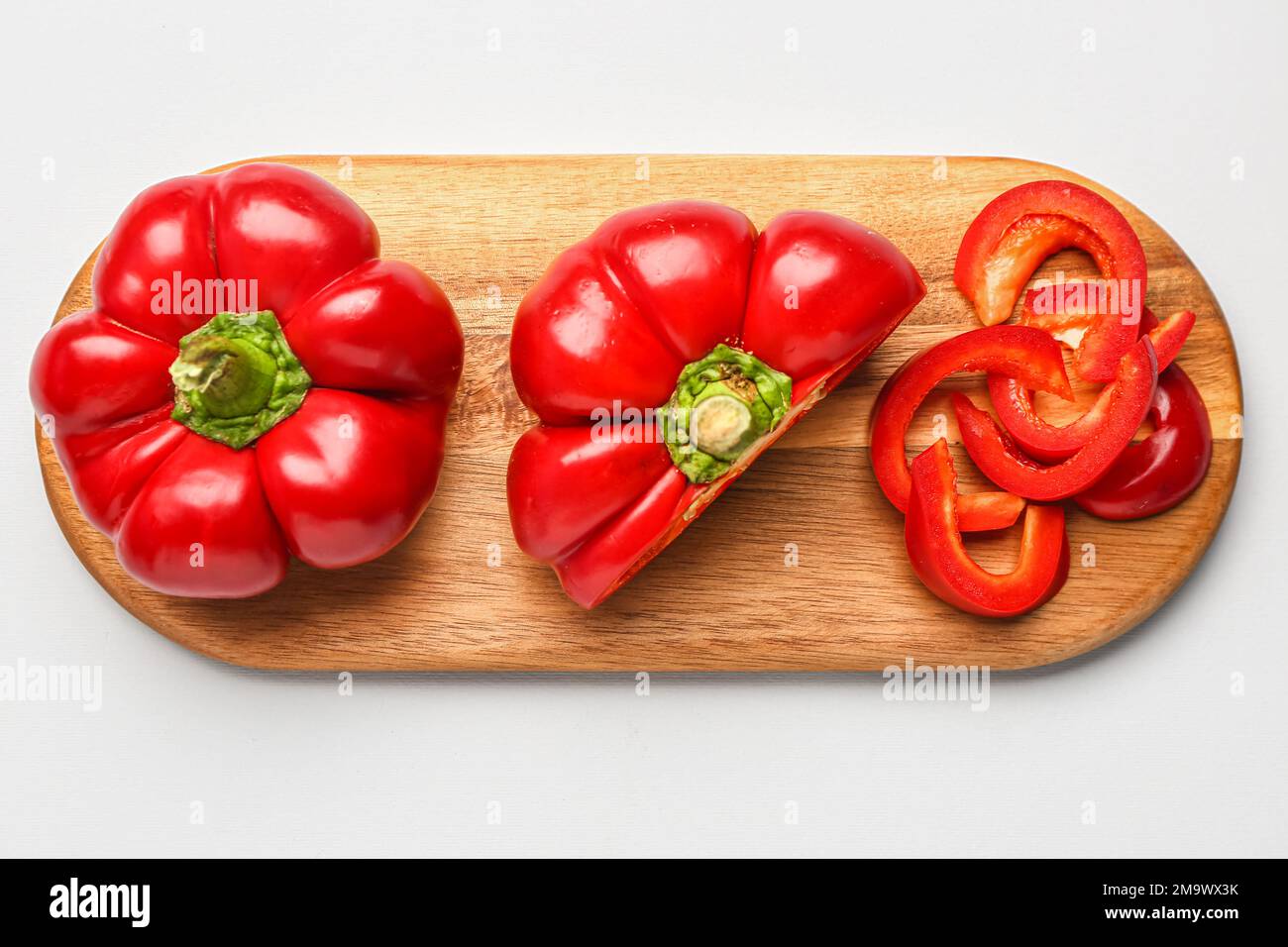 Wooden board with red bell peppers on white background Stock Photo - Alamy