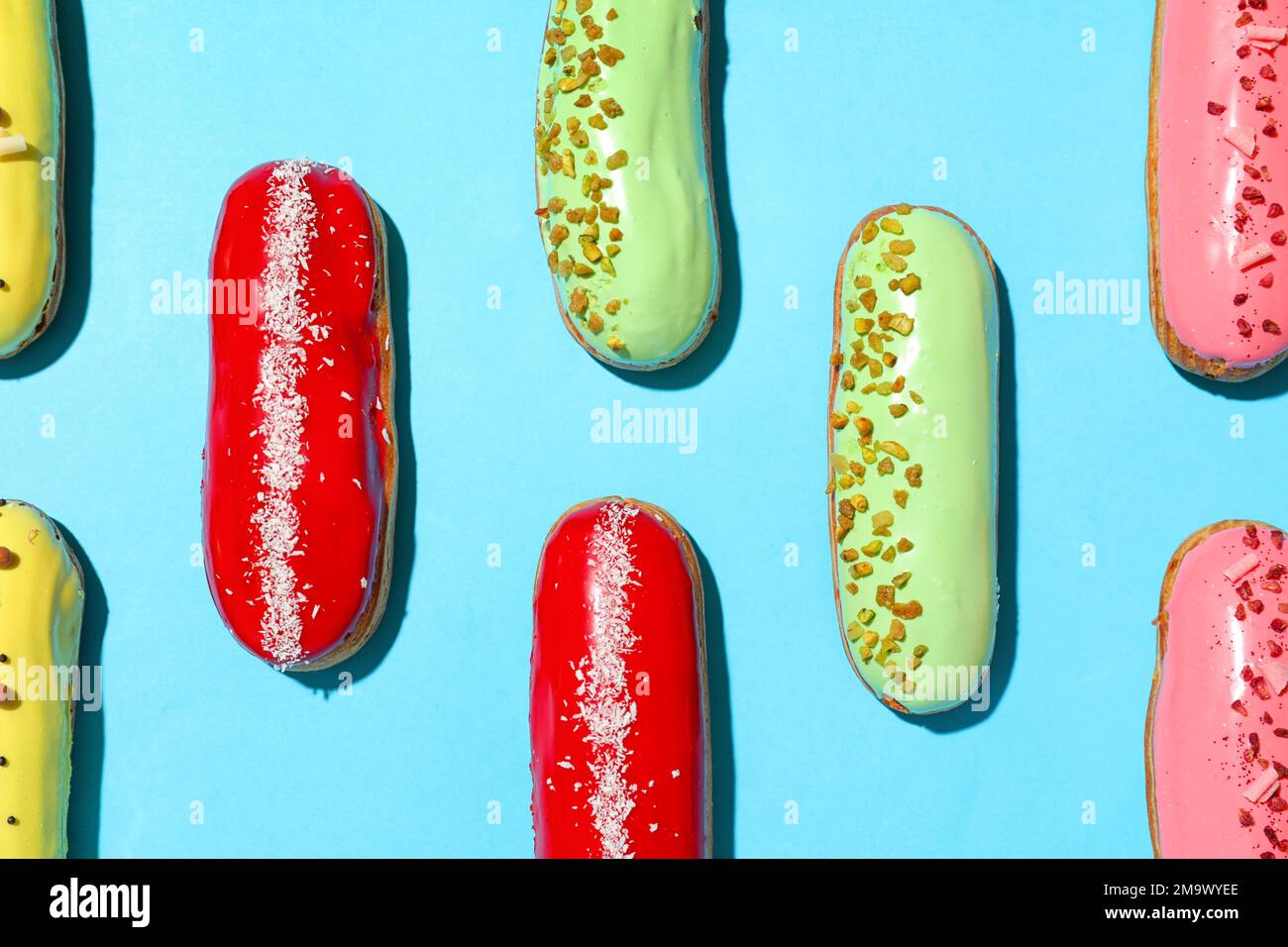 Composition with delicious eclairs on blue background Stock Photo
