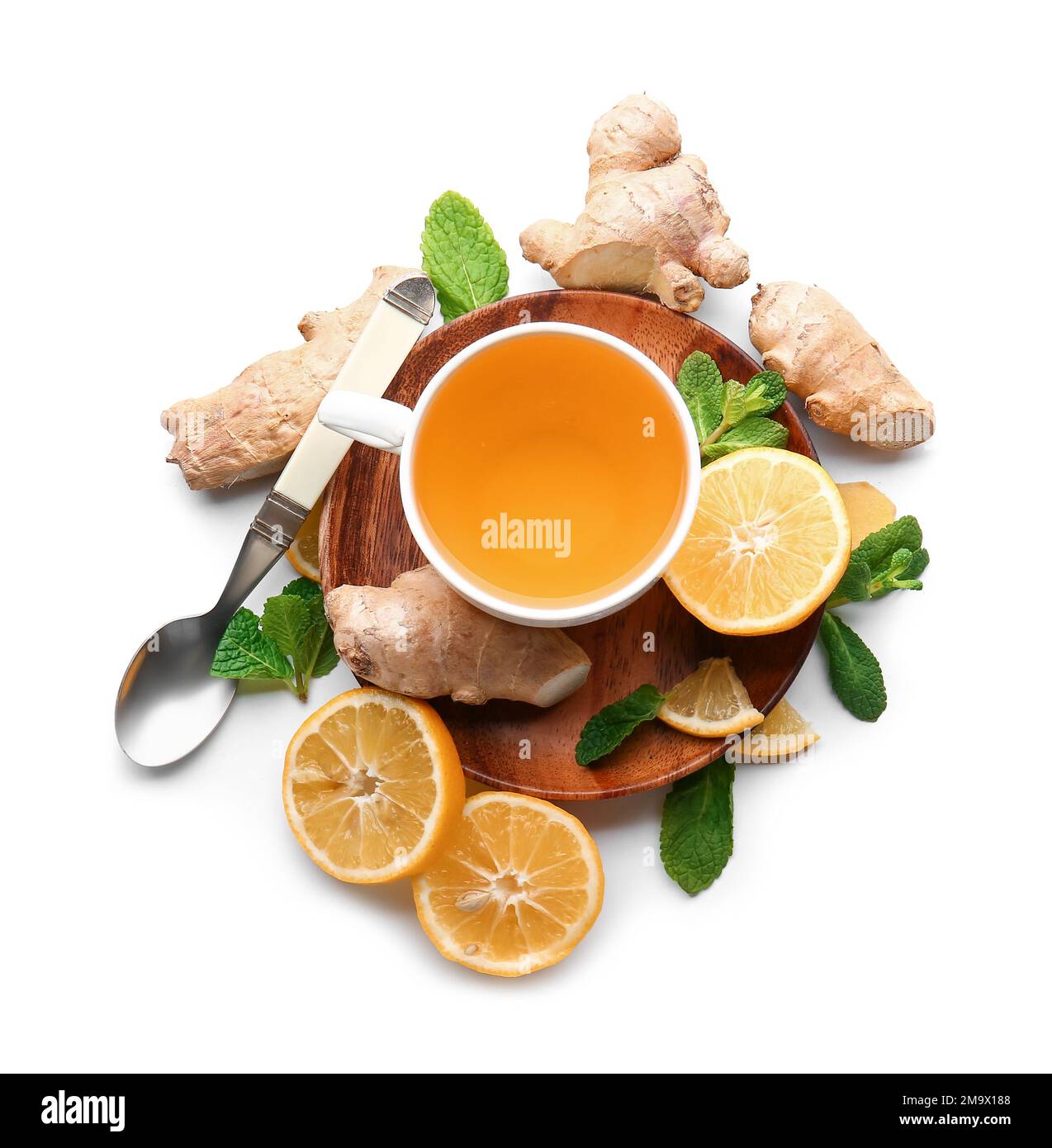 Wooden board with cup of tea, ginger, lemon and mint on white ...