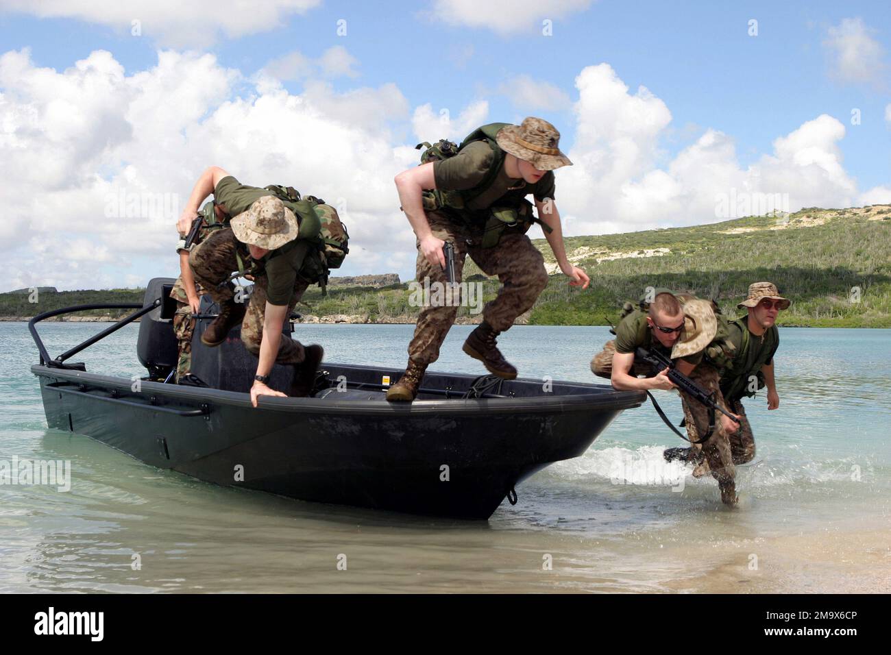 US Marine Corps (USMC) personnel with Kilo Company, 3rd Battalion, 25th Marines, jump from a Royal Dutch Marine boat during a beach assault exercise on the island of Curacao during Dutch Bilateral Training. Bilateral Training is an annual cooperative exchange between the USMC Reserves and the Royal Netherlands Marine Corps (RNMC). Country: Netherlands Antilles (ANT) Stock Photo
