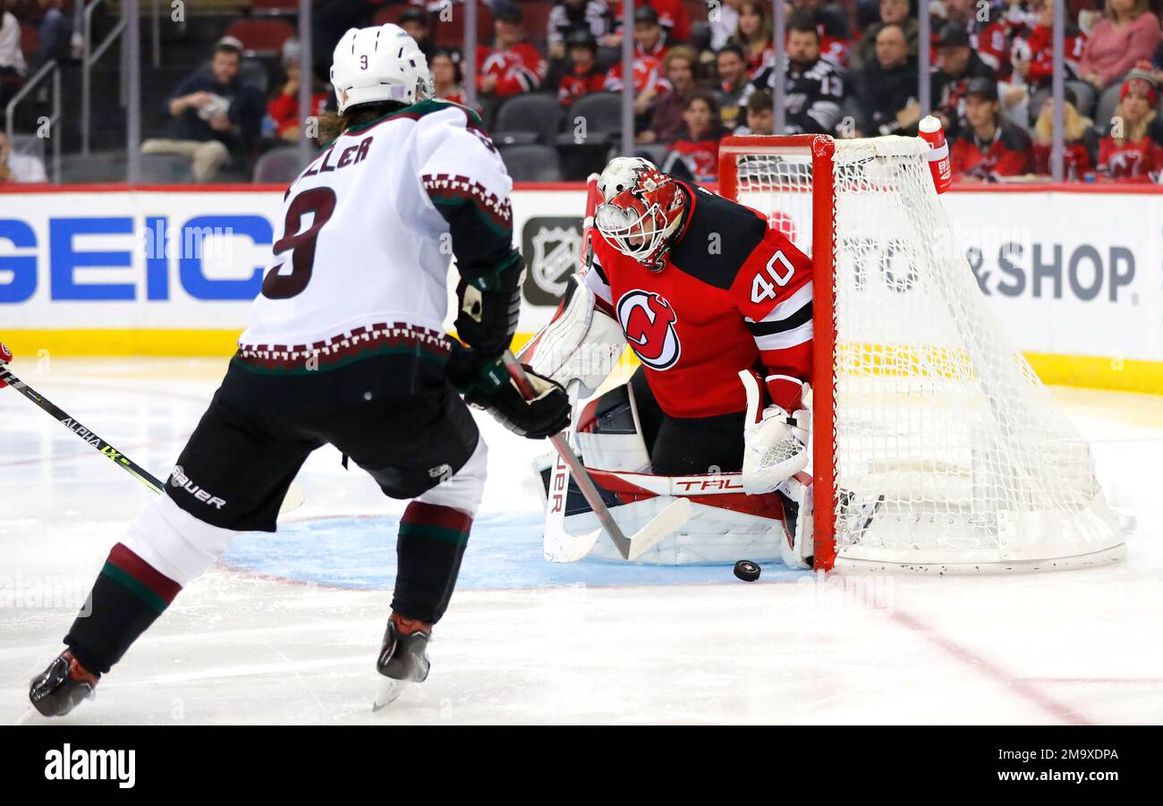 New Jersey Devils goaltender Akira Schmid (40) makes a save against Arizona  Coyotes right wing Clayton Keller (9) during the second period of an NHL  hockey game, Saturday, Nov. 12, 2022, in