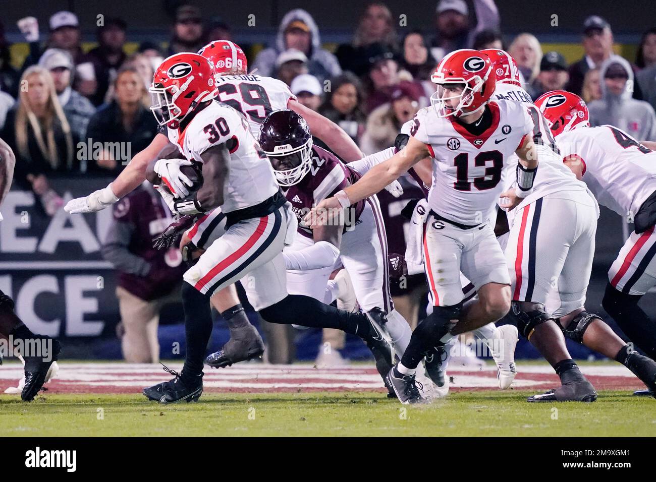 Georgia running back Daijun Edwards (30) takes a hand off from quarterback  Stetson Bennett (13) while Mississippi State defensive tackle Nathan  Pickering (22) pursues in the second half of an NCAA college