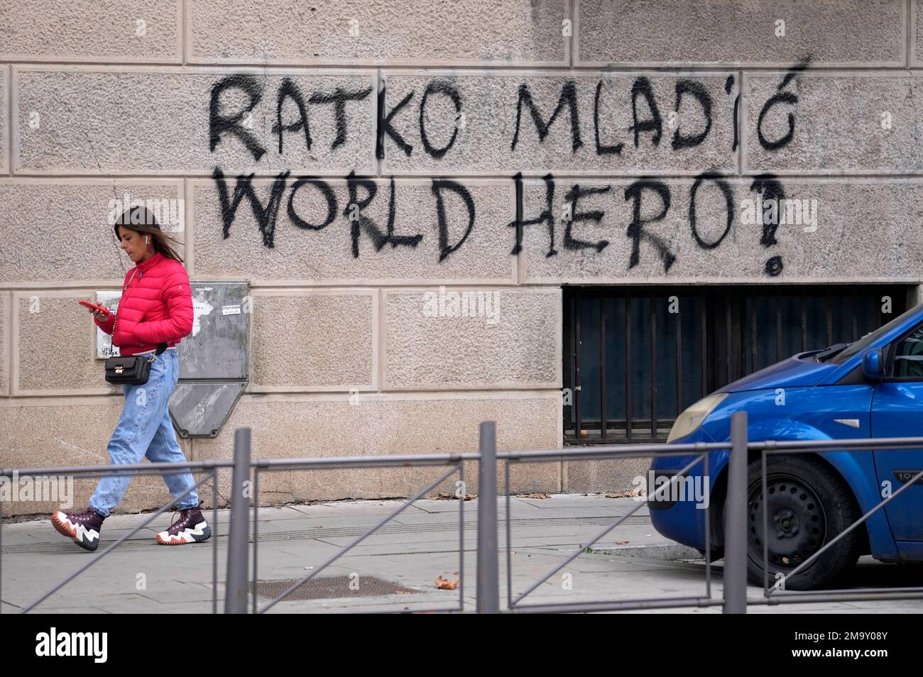 A woman walks past a graffiti in Belgrade, Serbia, Friday, Nov. 11