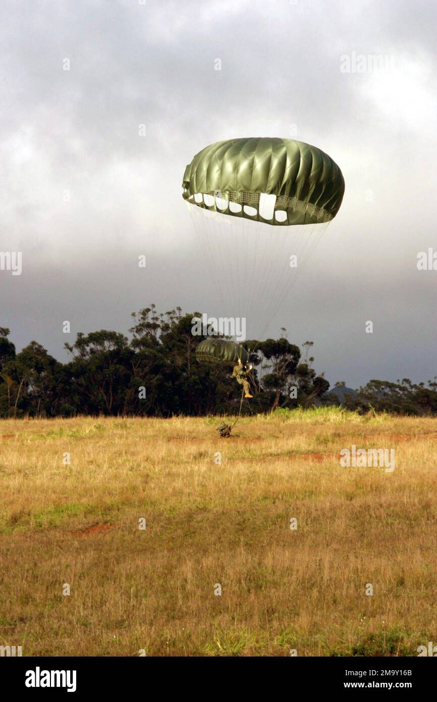 US Navy (USN) Hospital Corpsman Second Class (HM2) Daniel Valez, assigned to the 4th Force Reconnaissance, gently floats to earth while participating in a parachute drop during day combat equipment training at Schofield Barracks, Oahu, Hawaii (HI). (Duplicate image, see also DMSD0602552 or search 040316M9023R127). Base: Schofield Barracks, Oahu State: Hawaii (HI) Country: United States Of America (USA) Stock Photo