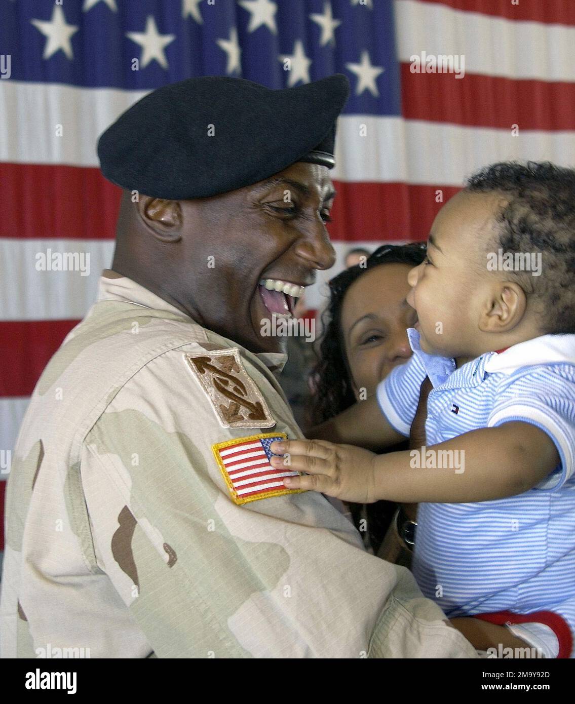 Reunion at Nellis Air Force Base, Nevada (NV), US Army (USA) Reservist STAFF Sergeant (SSG) James Smith, 257th Transportation Company (TRANS CO), Las Vegas, NV, holds his eight month old son Malik for the first time on returning home from a 13-month deployment to Kuwait and Iraq during Operation IRAQI FREEDOM. Subject Operation/Series: IRAQI FREEDOM Base: Nellis Air Force Base State: Nevada (NV) Country: United States Of America (USA) Stock Photo