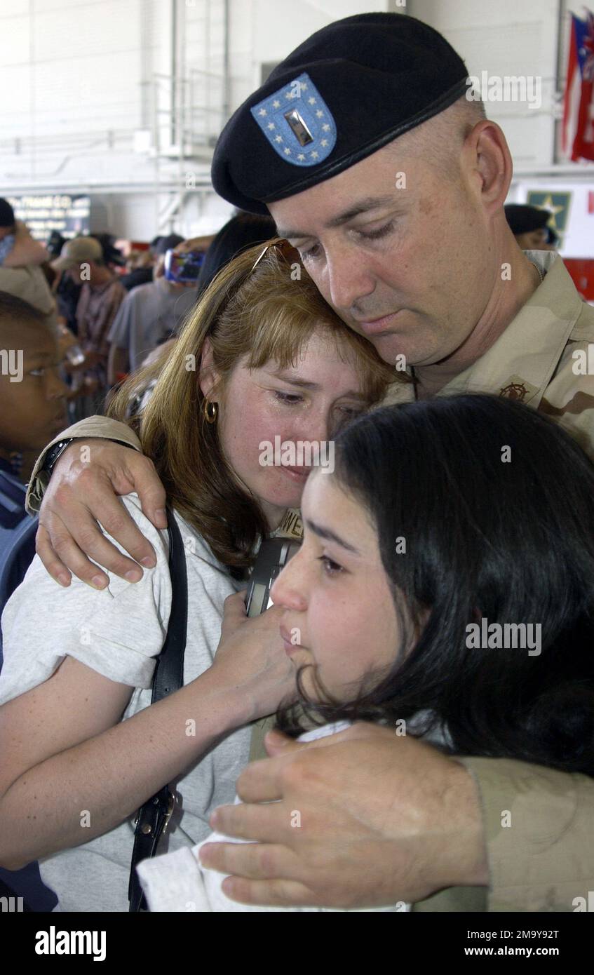 Reunion at Nellis Air Force Base, Nevada (NV), US Army (USA) Reservist Second Lieutenant (2LT) Johnathan Sowell, 257th Transportation Company (TRANS CO), Las Vegas, NV, hugs his wife Patty and daughter Juanita on returning home from an 18 month deployment in Kuwait and Iraq supporting Operation IRAQI FREEDOM. Subject Operation/Series: IRAQI FREEDOM Base: Nellis Air Force Base State: Nevada (NV) Country: United States Of America (USA) Stock Photo