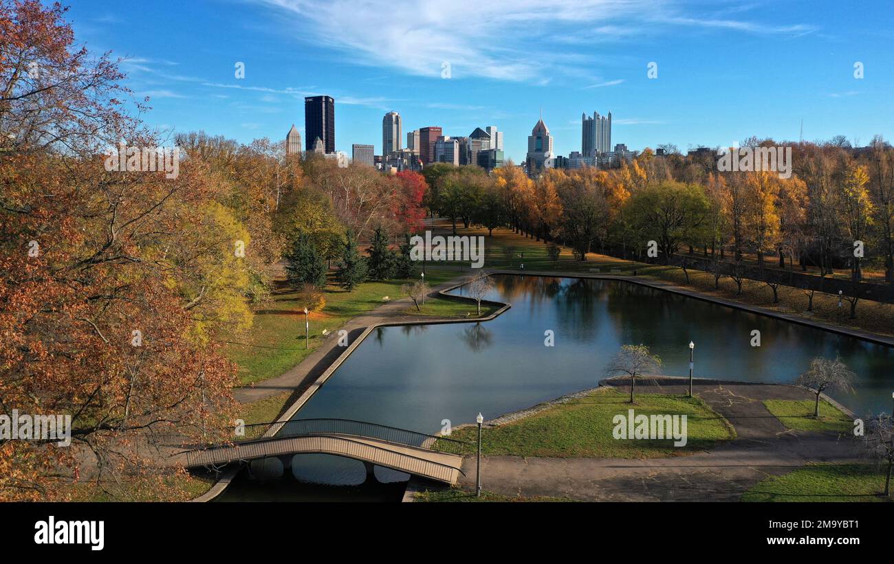 The skyline of downtown Pittsburgh rises behind the pond in Allegheny