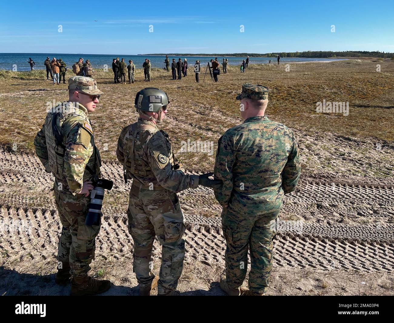 Soldiers of the 291st Digital Liaison Detachment, Maryland Army National Guard, integrate with Civil Affairs Officers from the 22nd Marine Expeditionary Unit observing civilians, members of the press, and US and Estonian forces following the amphibious landing of elements from Task Force 61 Naval Amphibious Forces Europe/ 2nd Marine Division (TF-61/2) and the 22nd Marine Expeditionary Unit in Saaremaa, Estonia during DEFENDER-Europe on May 21, 2022 and Estonian HEDGEHOG 22. The 291st Digital Liaison Detachment, Maryland Army National Guard, embeds into the multinational force headquarters to e Stock Photo