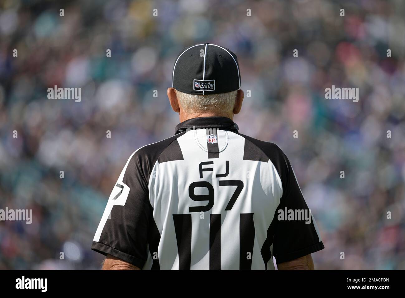 Field judge Tom Hill (97) wears a hat with a Crucial Catch patch