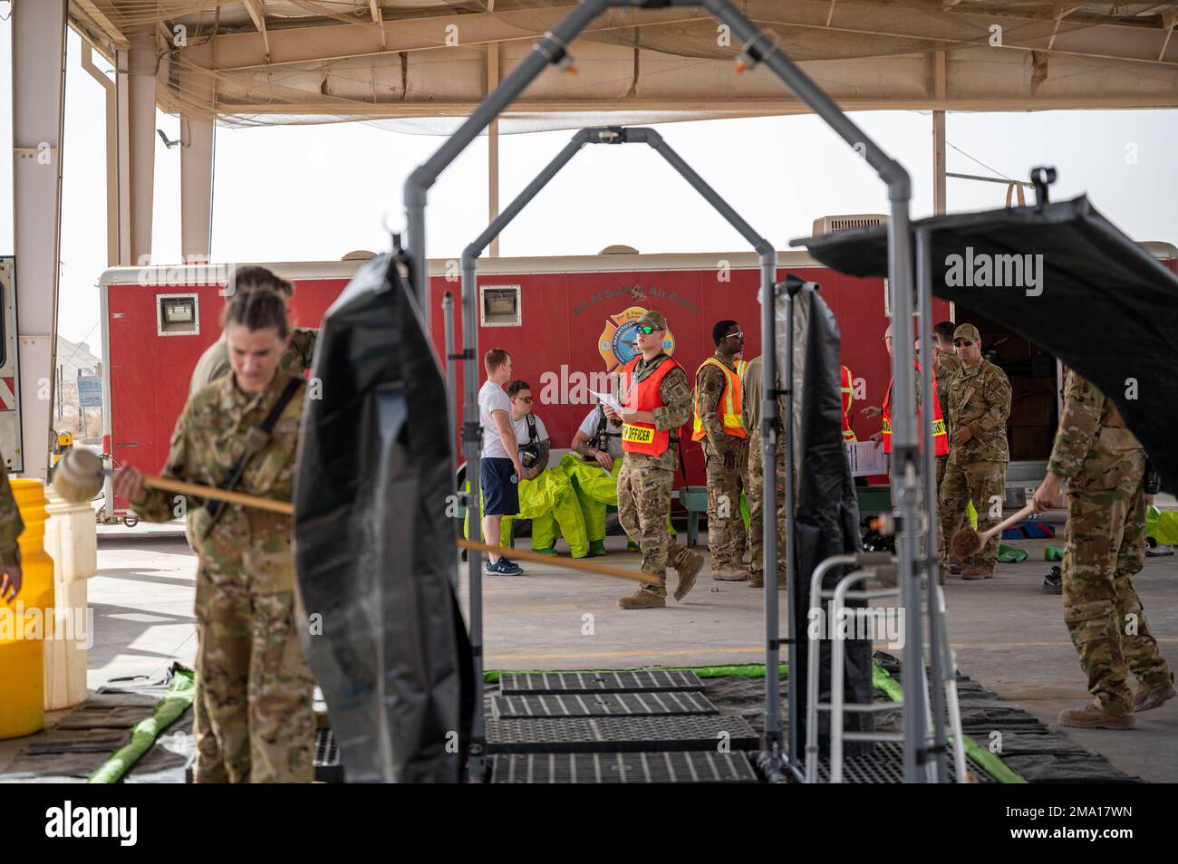 U.S. Airmen playing the roles of incident commander, public information officer, safety officer and operations officer, discuss the progress of a simulated hazardous materials scenario at Fire Station 2 at Ali Al Salem Air Base, Kuwait, May 22, 2022. The 386th Expeditionary Civil Engineer Squadron Fire Department conducted a certification evaluation for hazardous materials incident commanders and technicians on base. The hands-on portion of the certification consisted of three simulated scenarios: stopping a one-ton container, typically used for storage, from leaking chlorine from its fusible Stock Photo