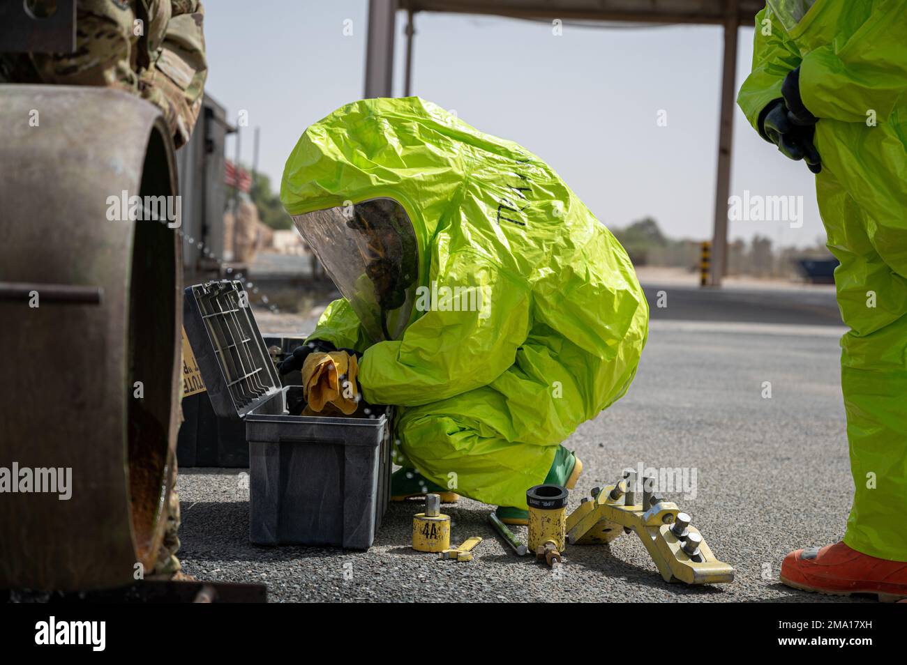 A U.S. Airman searches for tools needed to stop a simulated one-ton container from leaking chlorine at Fire Station 2 at Ali Al Salem Air Base, Kuwait, May 22, 2022. The 386th Expeditionary Civil Engineer Squadron Fire Department conducted a certification evaluation for hazardous materials incident commanders and technicians on base. The hands-on portion of the certification consisted of three simulated scenarios: stopping a one-ton container, typically used for storage, from leaking chlorine from its fusible plugs; the transportation of hazardous materials by rail; and bolting down an unstabl Stock Photo