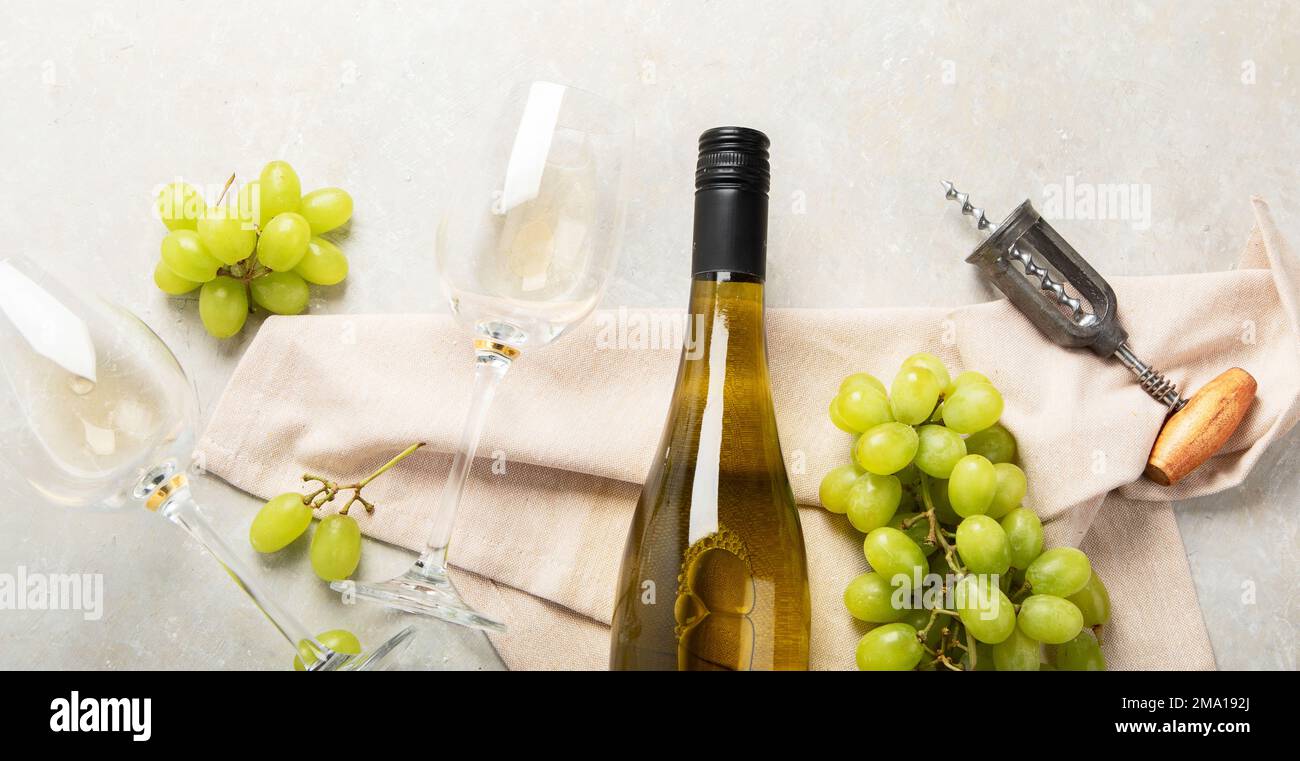 Flat-lay of white wine in glasses and corkscrews on a white background, top view, wide composition. Wine bar, winery, wine degustation concept. Panora Stock Photo