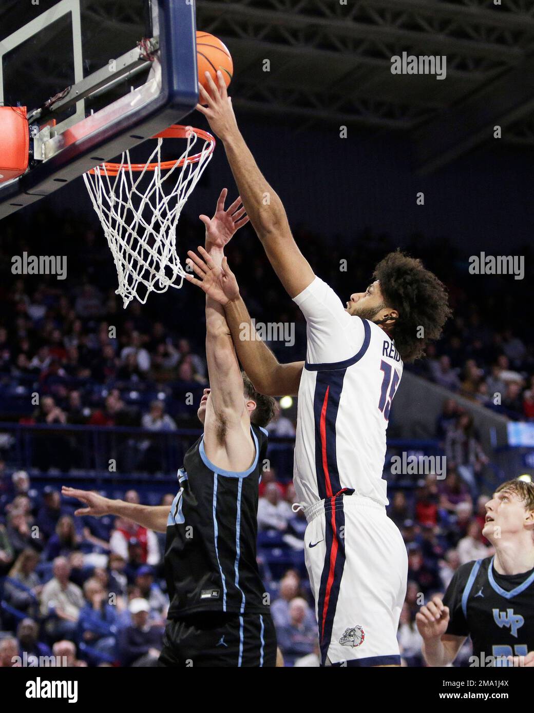 Gonzaga center Efton Reid III, right, shoots over Warner Pacific