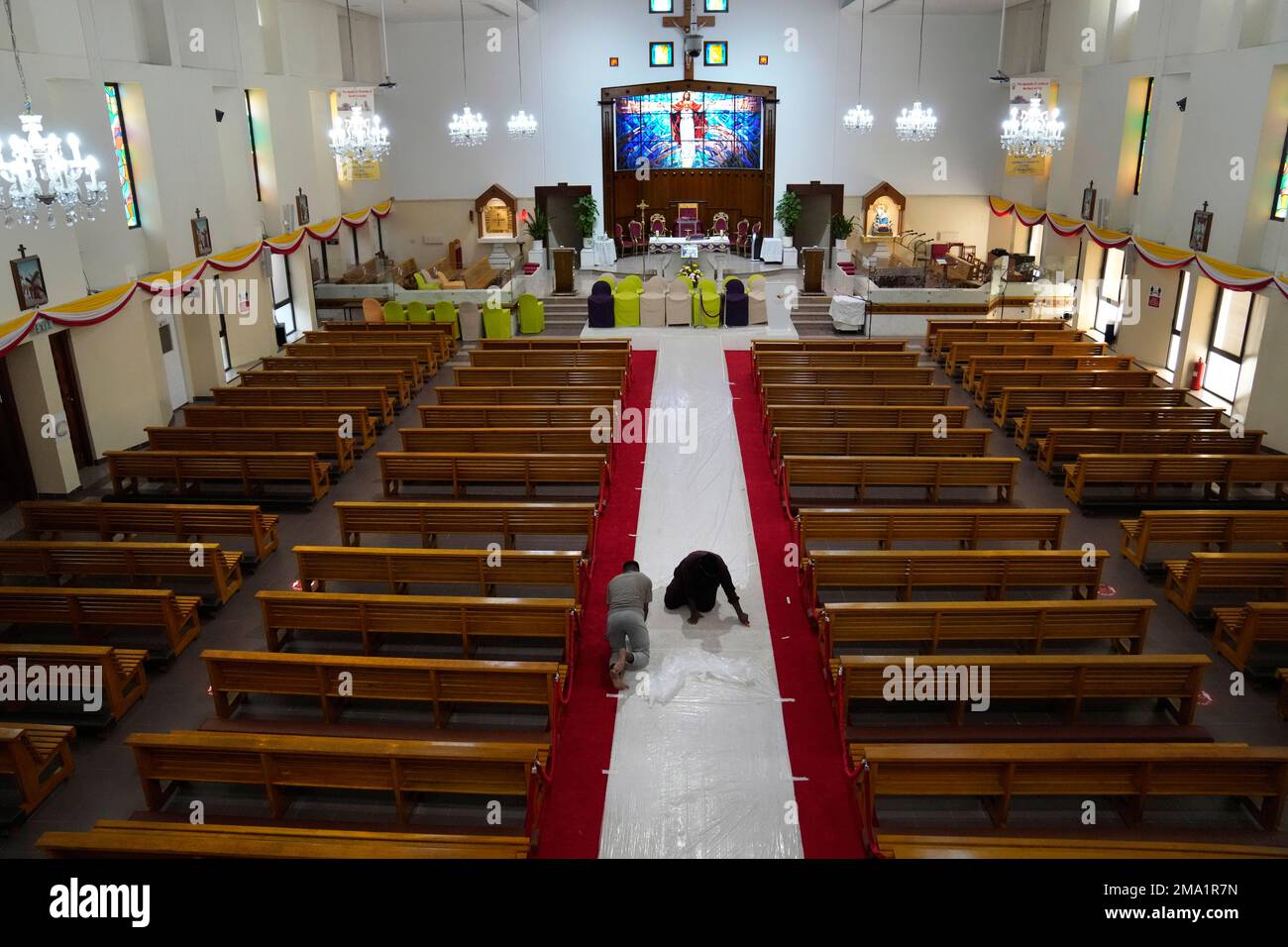 Workers adjust a red carpet at Sacred Heart church where the Pope ...