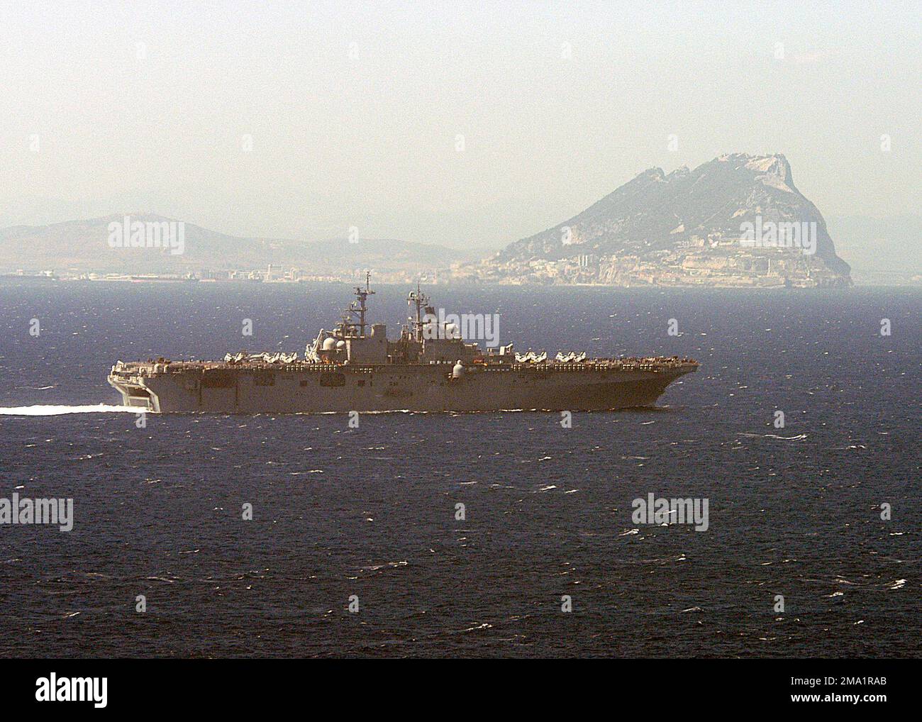 Starboard view of the US Navy (USN) Wasp Class Amphibious Assault Ship USS KEARSARGE (LHD 3) as she passes by the Rock of Gibraltar enroute to the Mediterranean Sea in support of Operation IRAQI FREEDOM (OIF) and the global war on terrorism. (Substandard image). Country: Atlantic Ocean (AOC) Stock Photo