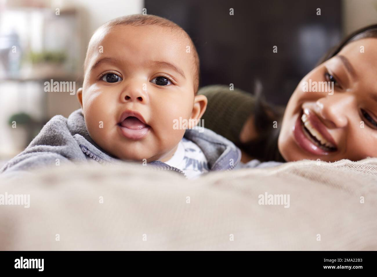 Having a baby is like falling in love again. a young woman relaxing with her adorable baby on the sofa at home. Stock Photo