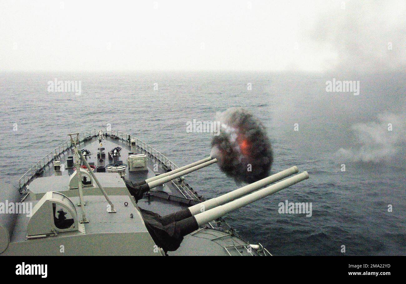 A view from onboard the Peruvian Navy DE RUYTER CLASS: Buque Armada Peruana (BAP) Cruiser, ALMIRANTE GRAU (CLM 81), showing the ships Bofors 6-inch, 152mm/53 twin guns firing off the starboard bow, during a naval amphibious assault exercise, while the ship is underway in the Pacific Ocean, during Exercise UNITAS 45-04. Unitas exercises are the largest multilateral exercise in the Southern Hemisphere. Designed to improve the operational readiness and interoperability of the United States and South American Naval, Coast Guard, and Marine forces, while promoting friendship, professionalism and un Stock Photo