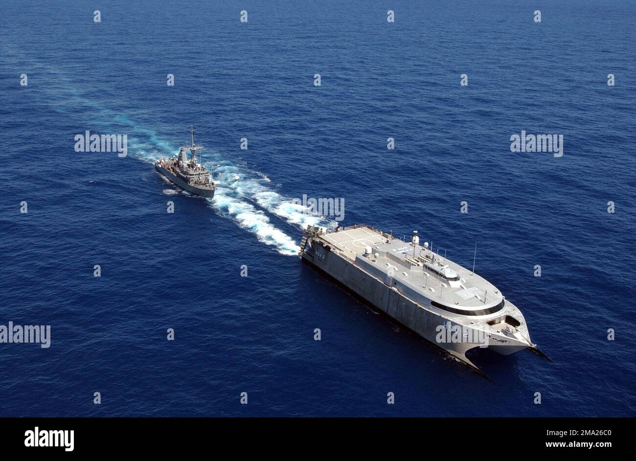 040710-N-6551H-144. [Complete] Scene Caption: The US Navy (USN) experimental High Speed Vehicle 2 (HSV 2) Swift refuels the Mine Countermeasures Ship USS AVENGER (MCM 1) off the coast of Hawaii (HI) during Exercise RIM OF THE PACIFIC (RIMPAC) 2004. The Swift is a wave-piercing aluminum-hulled catamaran that can move at speeds greater than 45 knots. With a draft allowing it to navigate in only 12 feet of water it can easily maneuver in and out of littoral environments. RIMPAC is the largest international maritime exercise in the waters around the Hawaiian Islands. This years exercise includes s Stock Photo