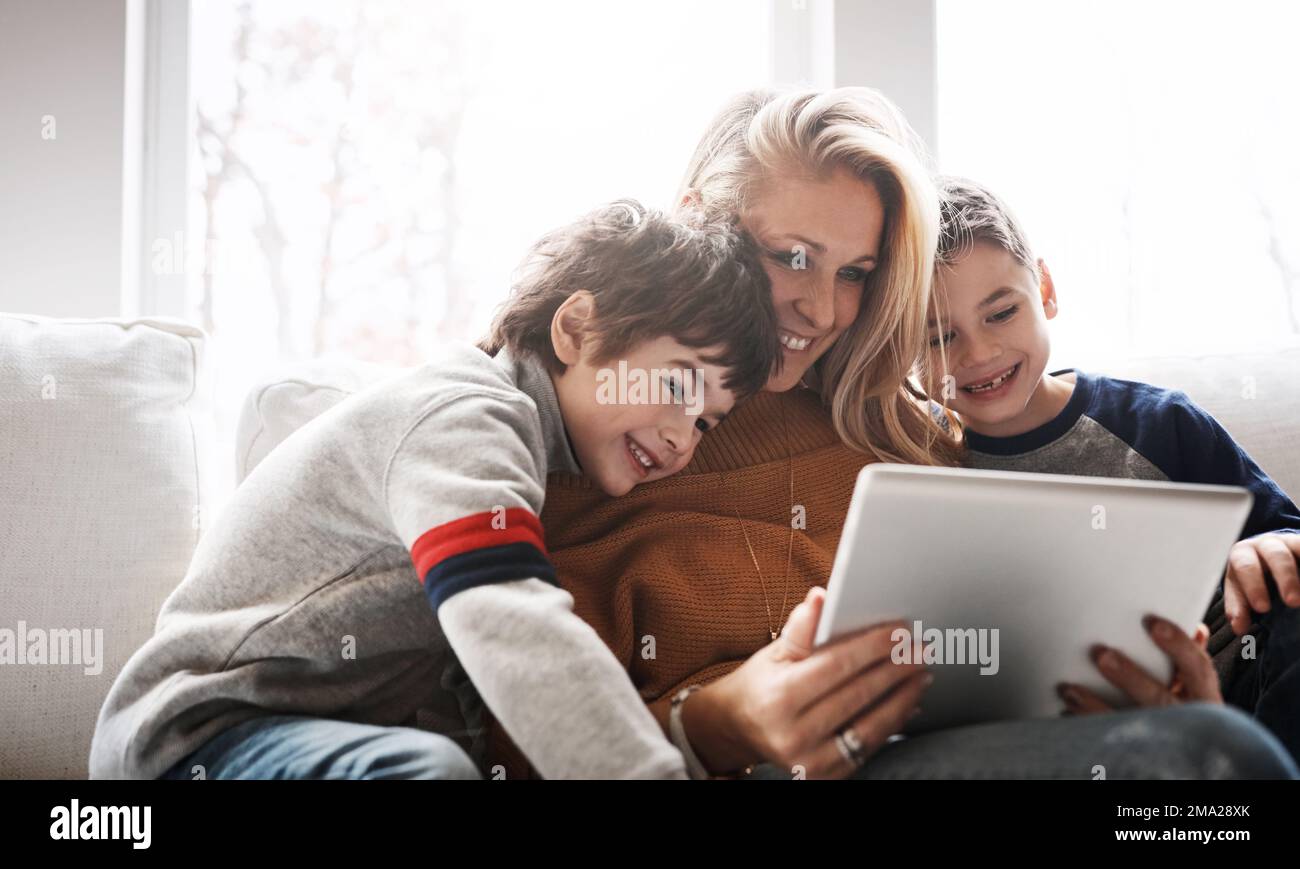 Relax, tablet and mom with children on sofa bonding, quality time and streaming movies on weekend. Love, family home and mom and kids with digital Stock Photo