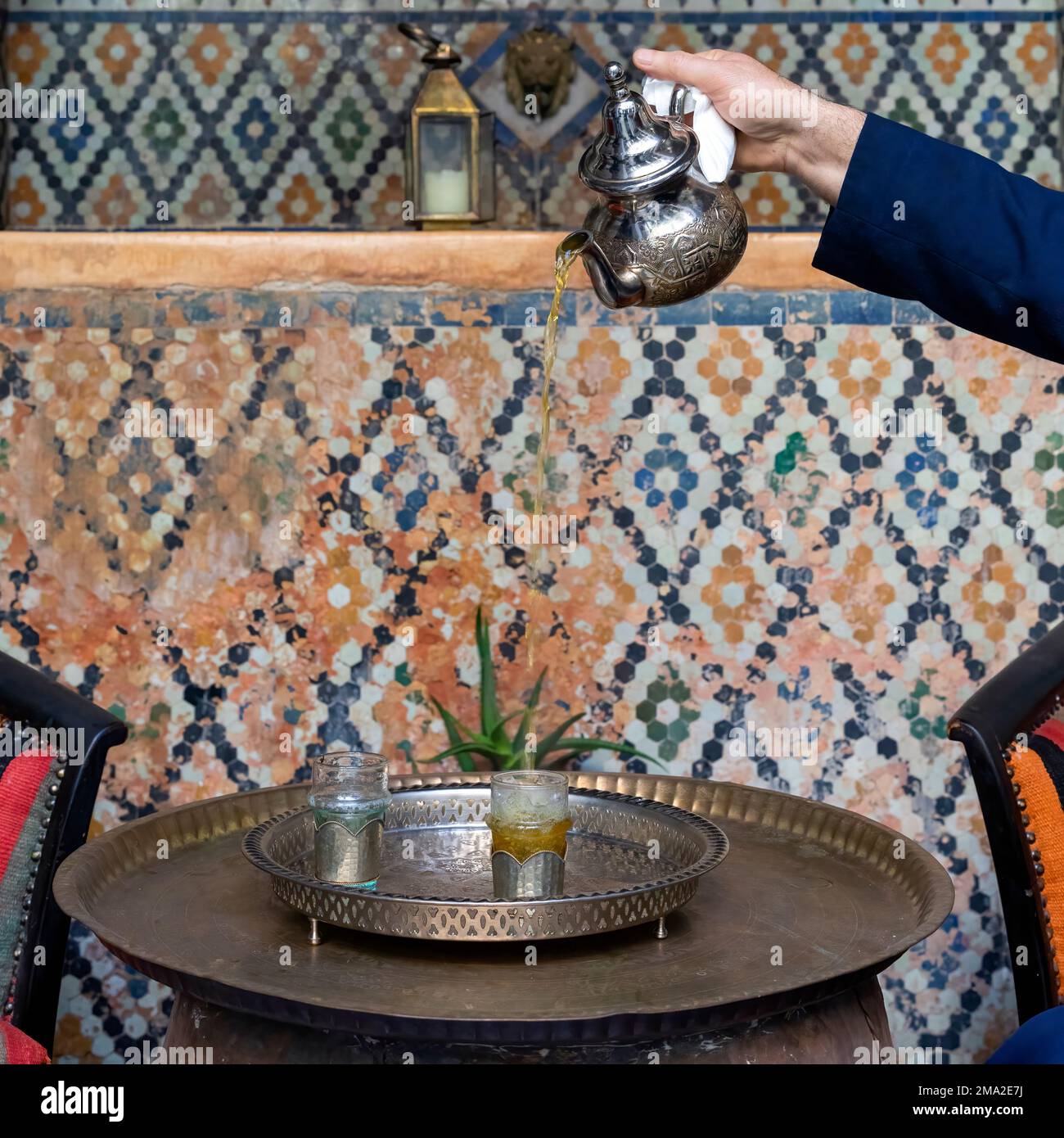 Moroccan serving mint tea in the traditional way, Marrakech Stock Photo