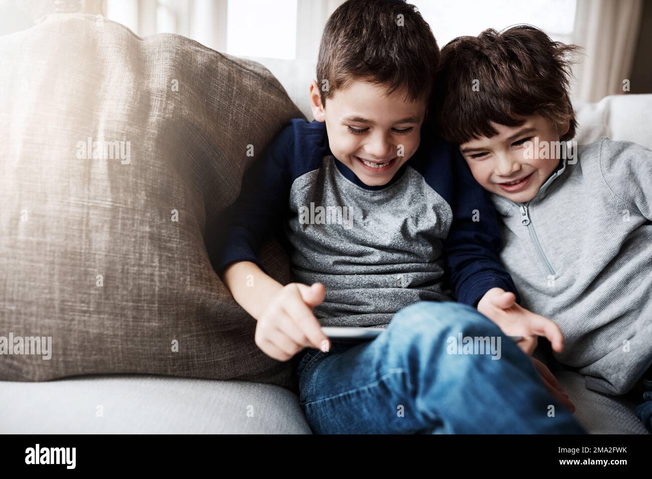 Boy siblings, tablet and sofa with laugh, funny meme and digital app