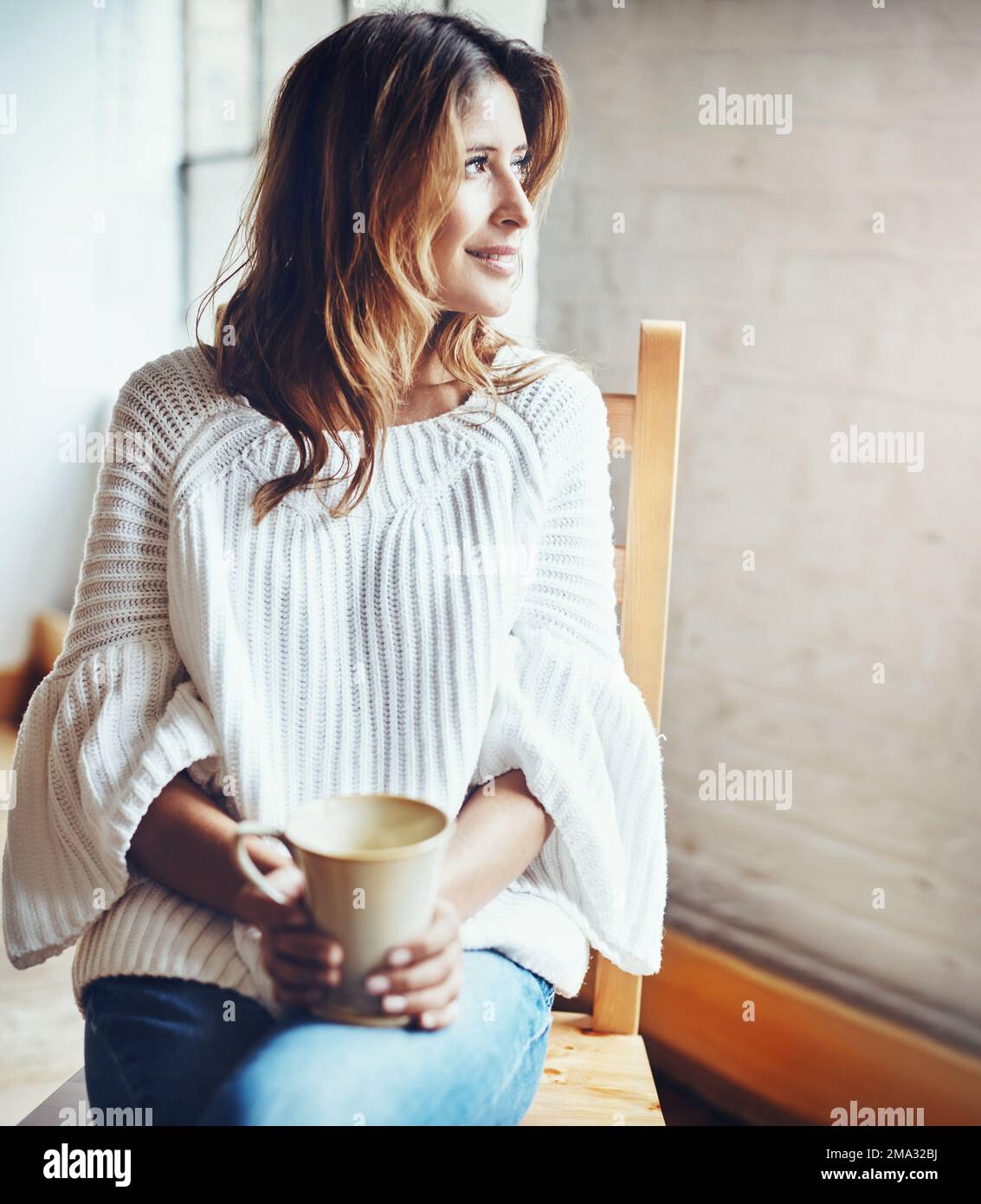 Happy, relax and woman drinking coffee while daydreaming in her home, calm and quiet on wall background. Tea, contemplation and female enjoying a Stock Photo