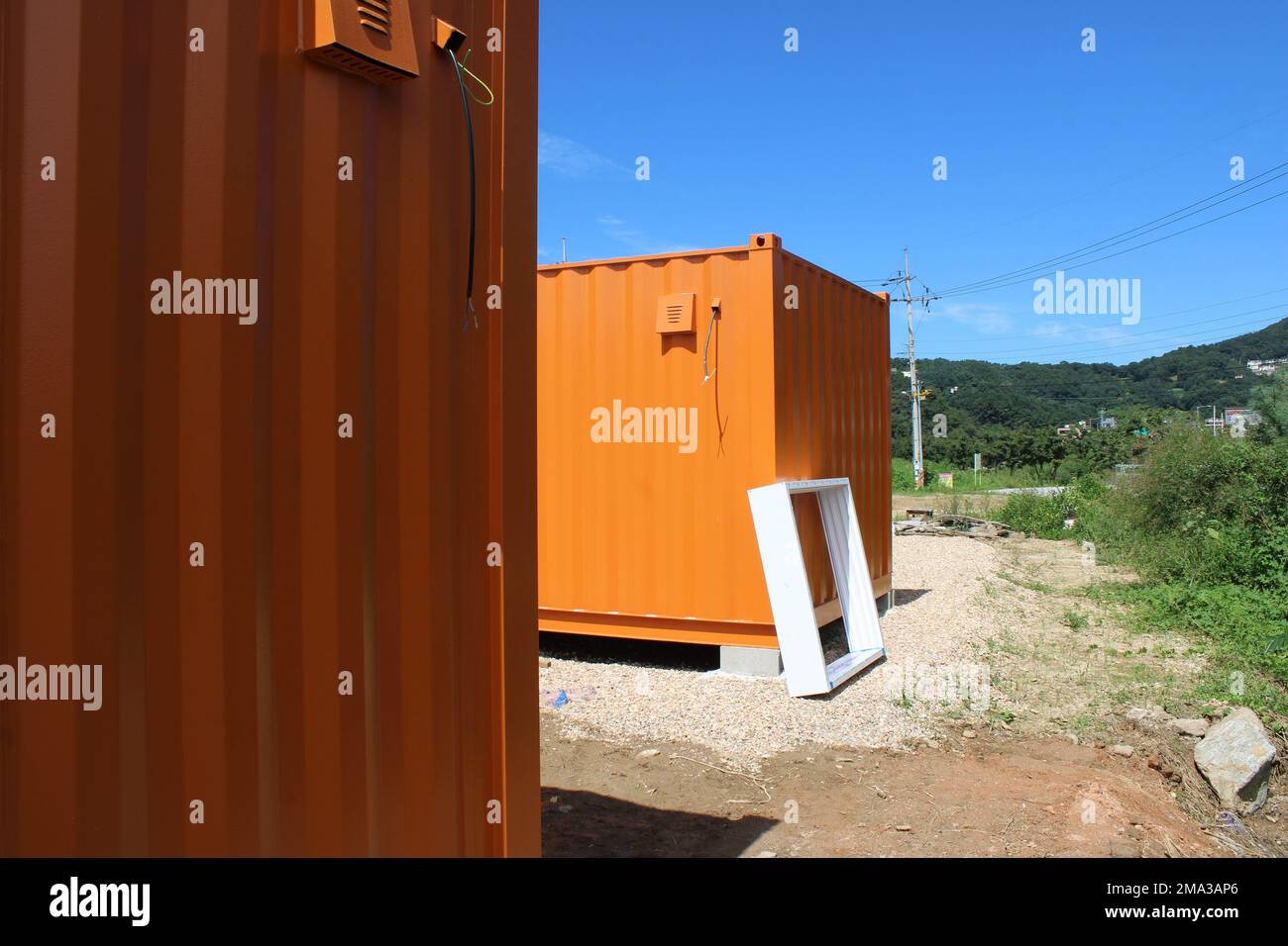 Orange shipping container office in rural construction site Stock Photo