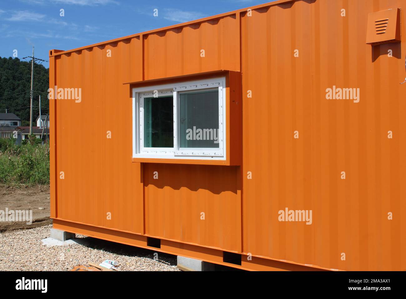 Orange shipping container office in rural construction site Stock Photo