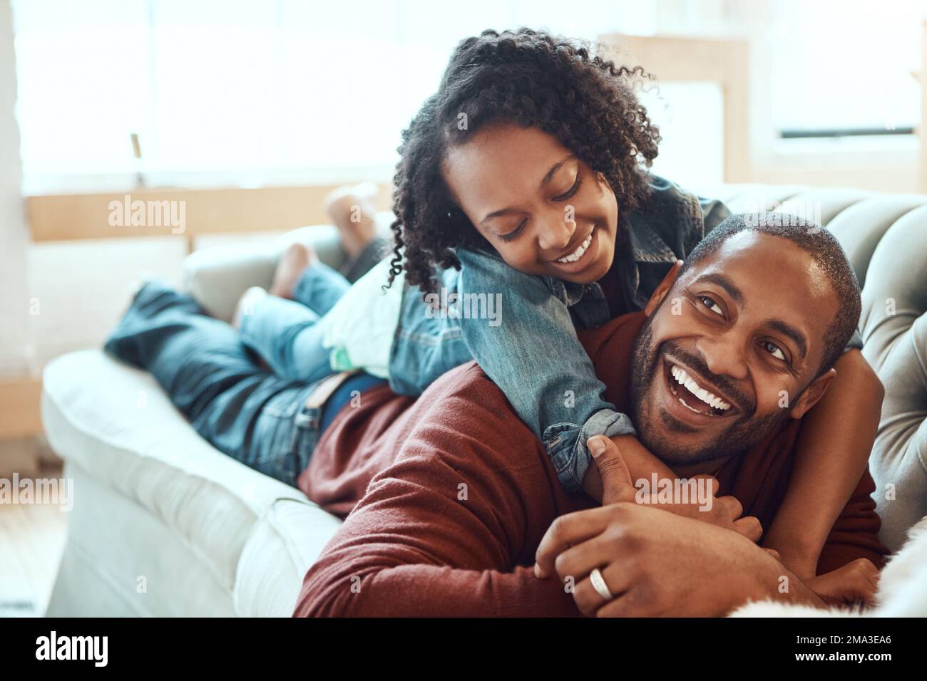 Black family, love and father with girl on sofa enjoying quality time, bonding and relax together on weekend. Living room, happiness and daughter Stock Photo