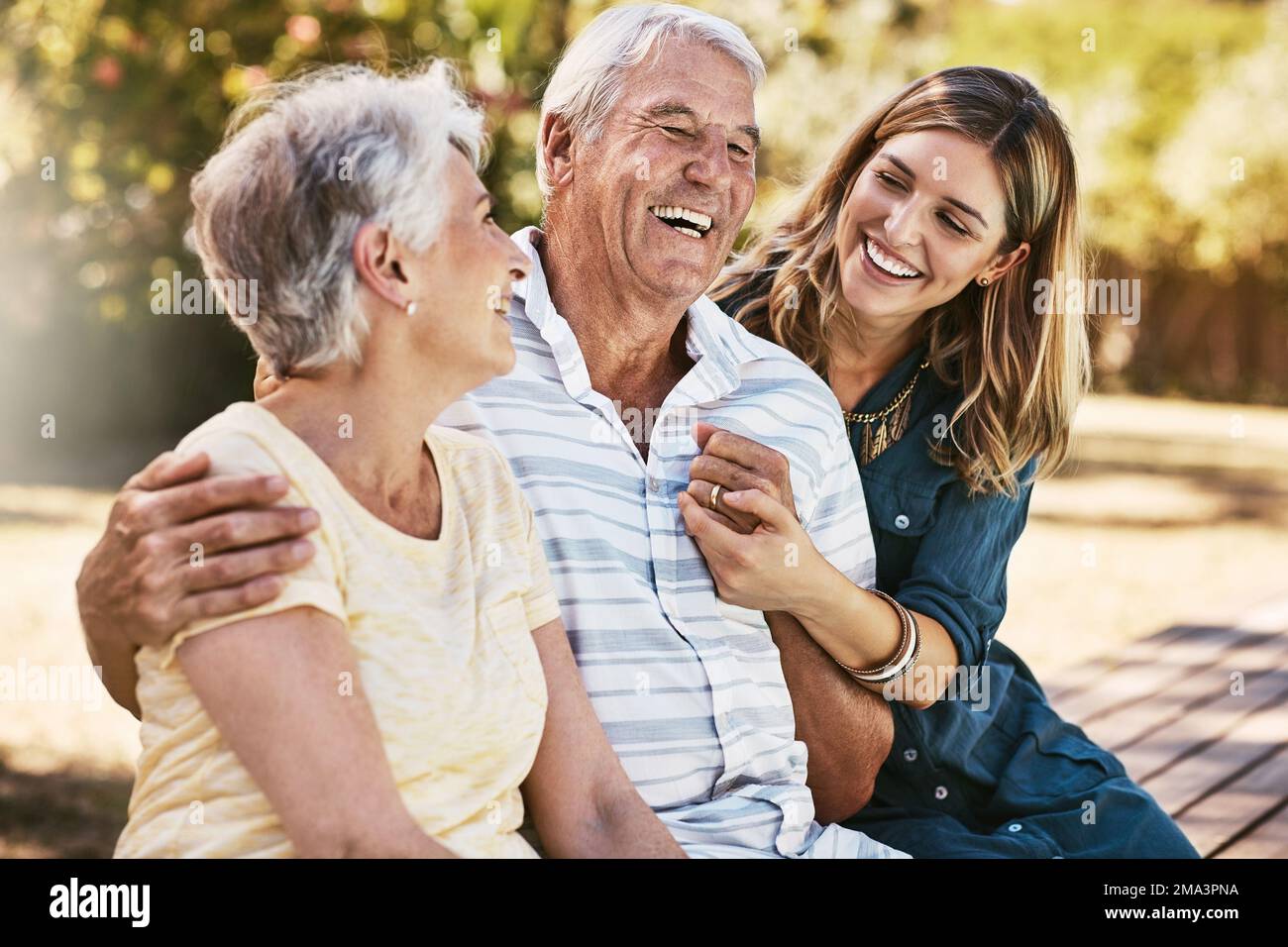Woman, grandparents and hug for family summer vacation, holiday or break together in the outdoors. Happy grandma, grandpa and daughter with smile in Stock Photo