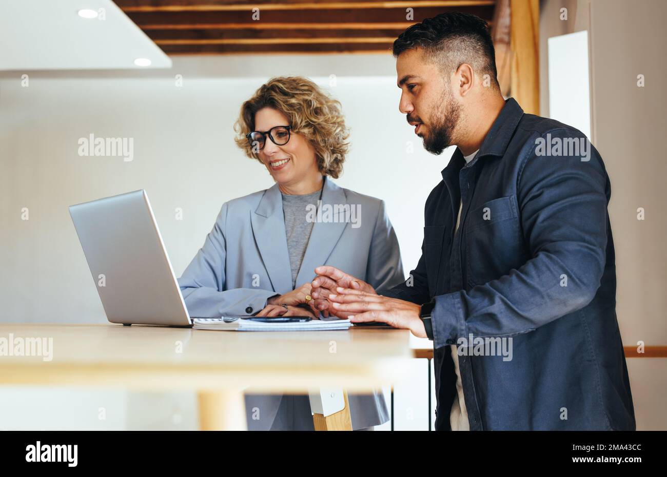 business people discussing their work progress using a laptop in an ...