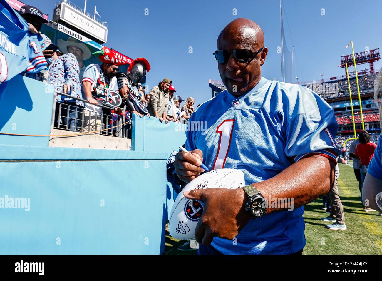 Former Houston Oiler quarterback Warren Moon signs an autograph before