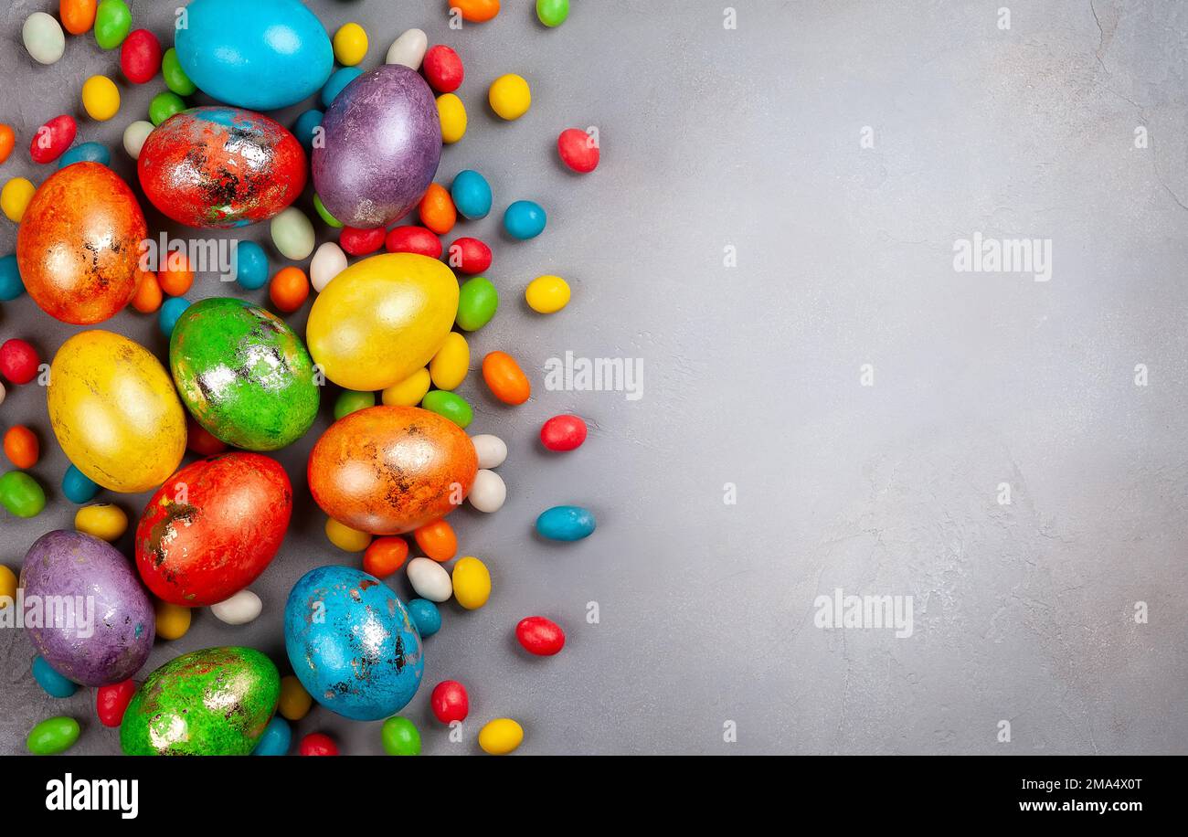 Colorful Easter eggs and chocolate Easter sweets  on grey background. Top view with copy space. Festive Easter concept. Stock Photo