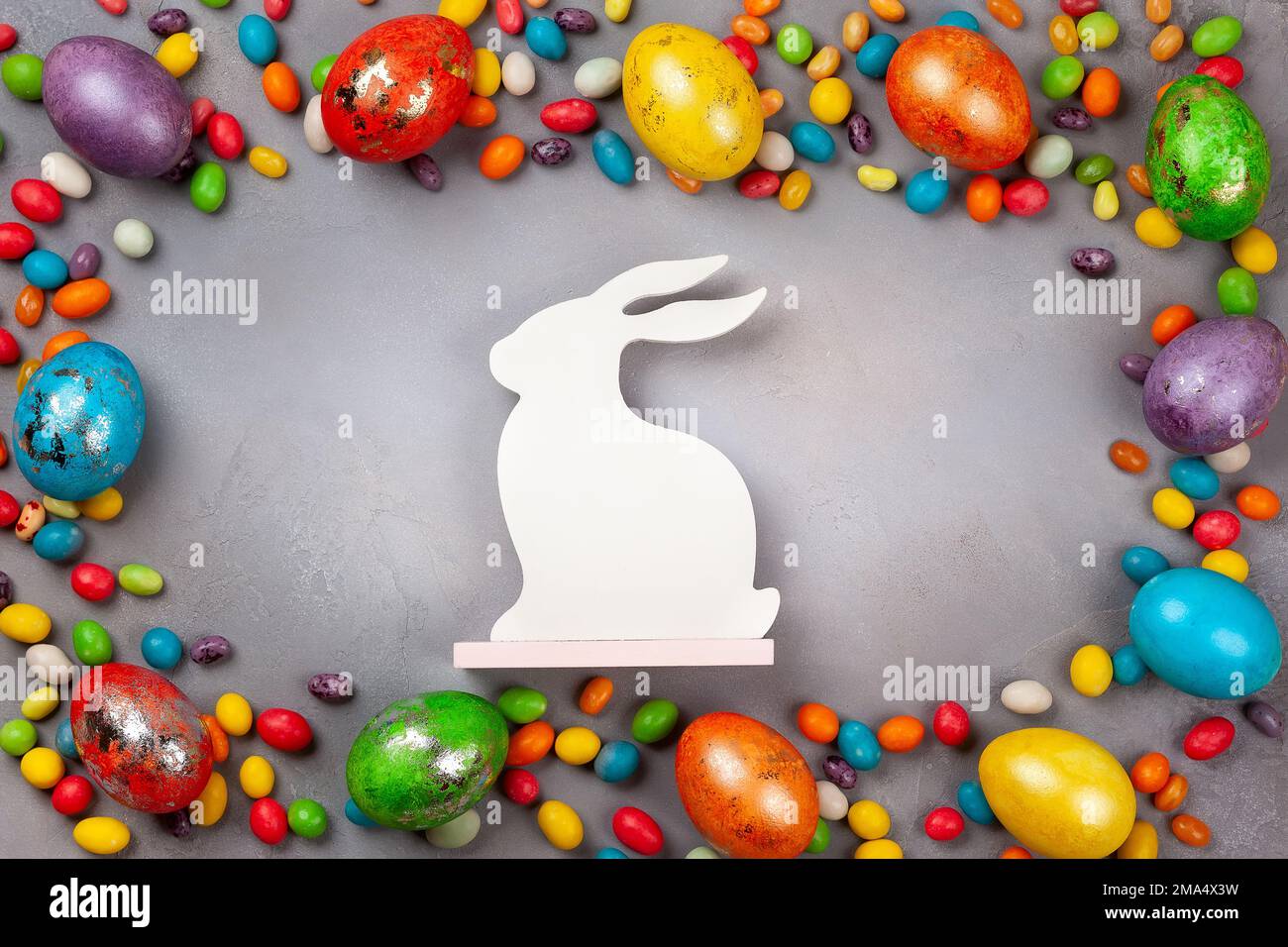 Colorful Easter eggs,chocolate Easter sweets and bunny  on grey background. Top view with copy space. Festive Easter concept. Stock Photo