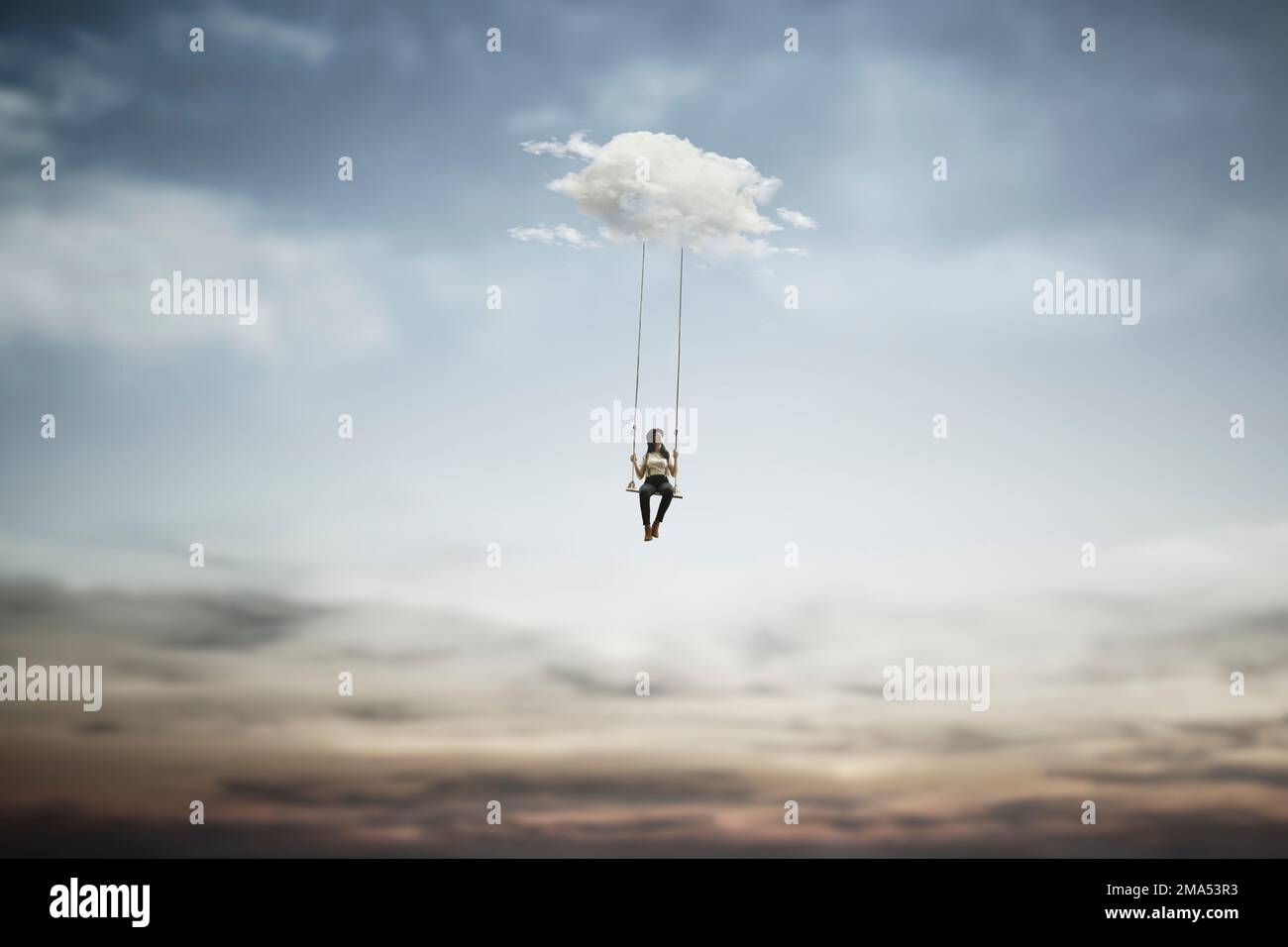 surreal woman having fun on a swing hanging from a cloud, abstract concept Stock Photo