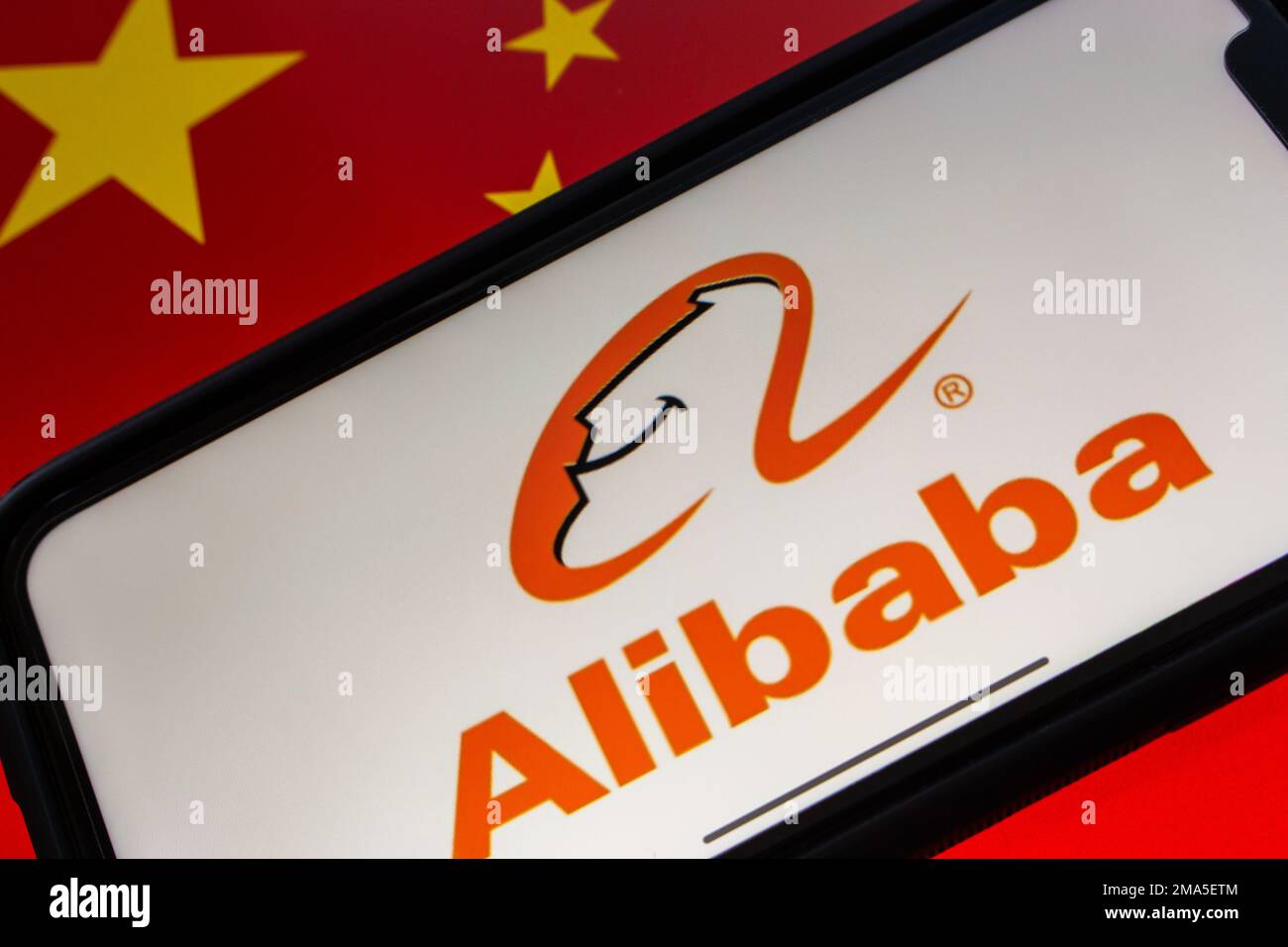 The logo of Alibaba seen in an iPhone on Chinese flag background ...