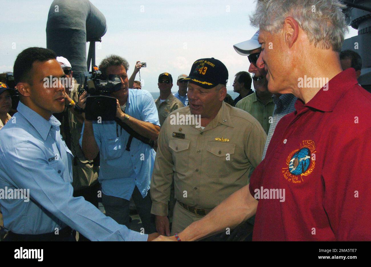 050220-N-5067K-018. [Complete] Scene Caption: Former US President William J. Clinton shakes the hand of US Navy (USN) SEAMAN (SN) Yandy Hernandez as he congratulates him aboard the Whidbey Island Class Amphibious Dock Landing Ship USS FORT MCHENRY (LSD 43). USN SN Hernandez conducted more than 200 critical crane lifts for over 500,000 pounds of relief supplies during Operation UNIFIED ASSISTANCE. USN Sailors and US Marine Corps (USMC) Marines greeted former Presidents Clinton and George H. W. Bush as they toured various spaces aboard the ship receiving operational briefings on each sections pa Stock Photo