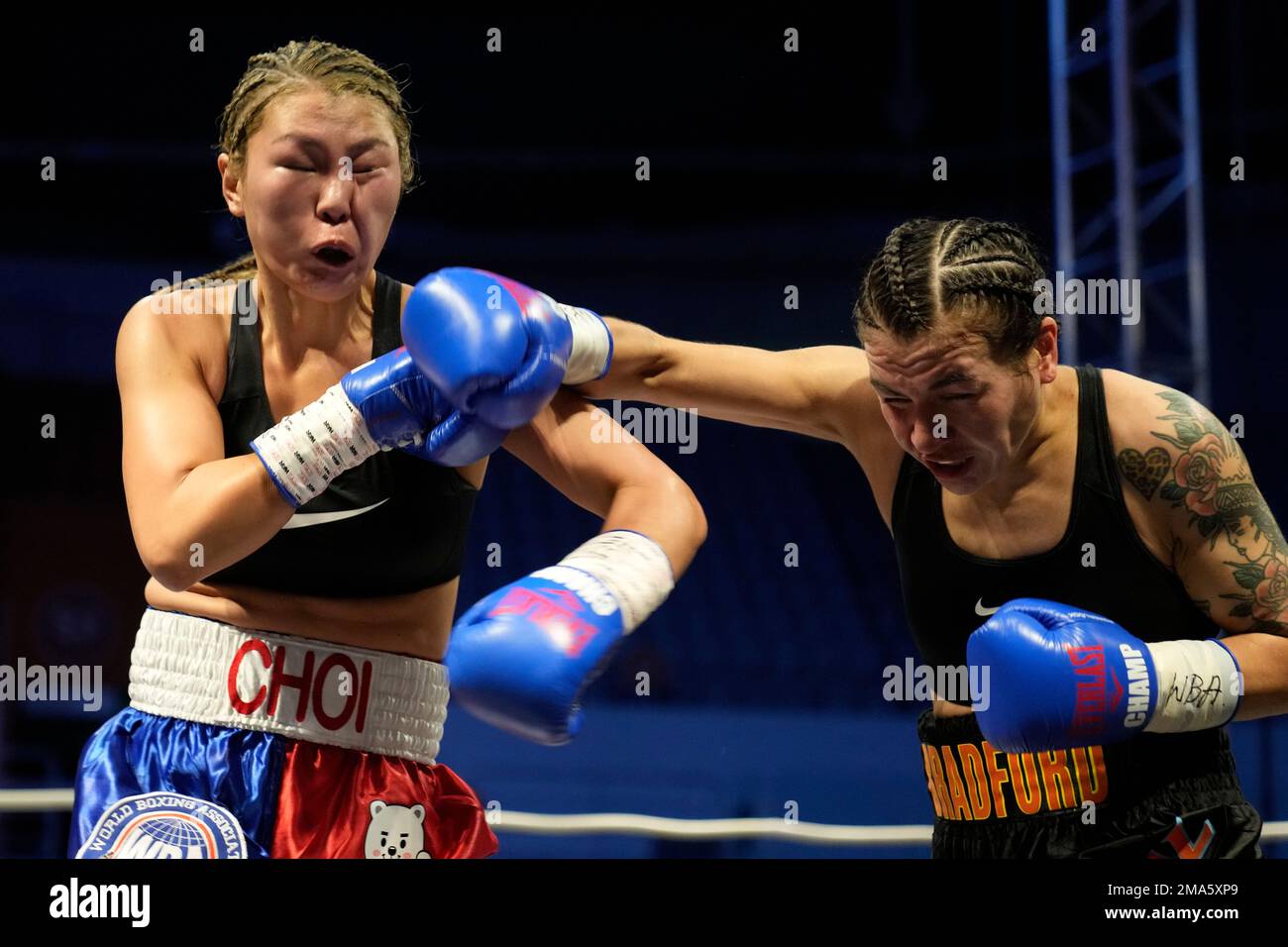 Challenger Vanessa Bradford of Canada lands her punch to South Korean  champion Choi Hyunmi, a former North Korean defector, left, during the  second round of the WBA women's super featherweight title boxing