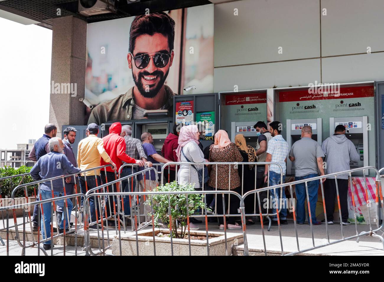 Lebanese people queue in front of a bank's ATMs in Zahlé, Lebanon, April 2022 Stock Photo